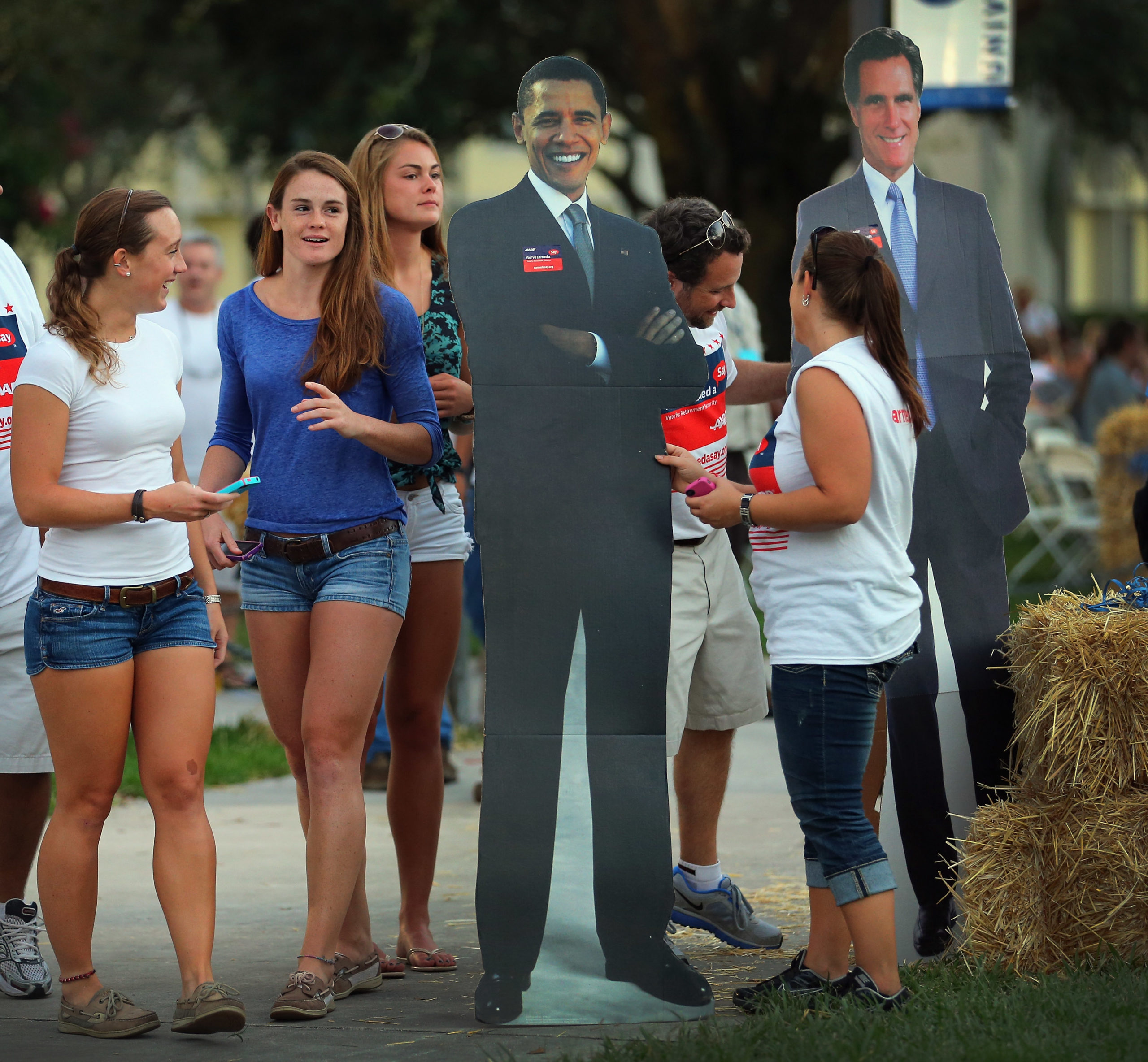People look at card board cutouts of U.S. President Barack Obama and Republican presidential candidate Mitt Romney at Lynn University as the campus prepares for the final presidential debate October 20, 2012 in Boca Raton, Florida. The debate, which will be held on Monday, October 22, will mark the final meeting between the two candidates before the general election on November 6th. (Photo by Joe Raedle/Getty Images)