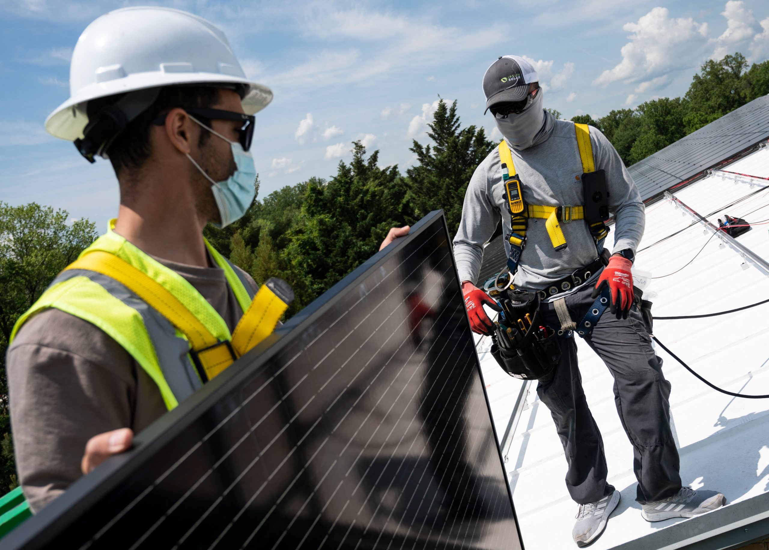Workers unload solar panels on the roof of the Peace Lutheran Church in Alexandria, Virginia, on May 17, 2021. (Andrew Caballero-Reynolds/AFP via Getty Images)