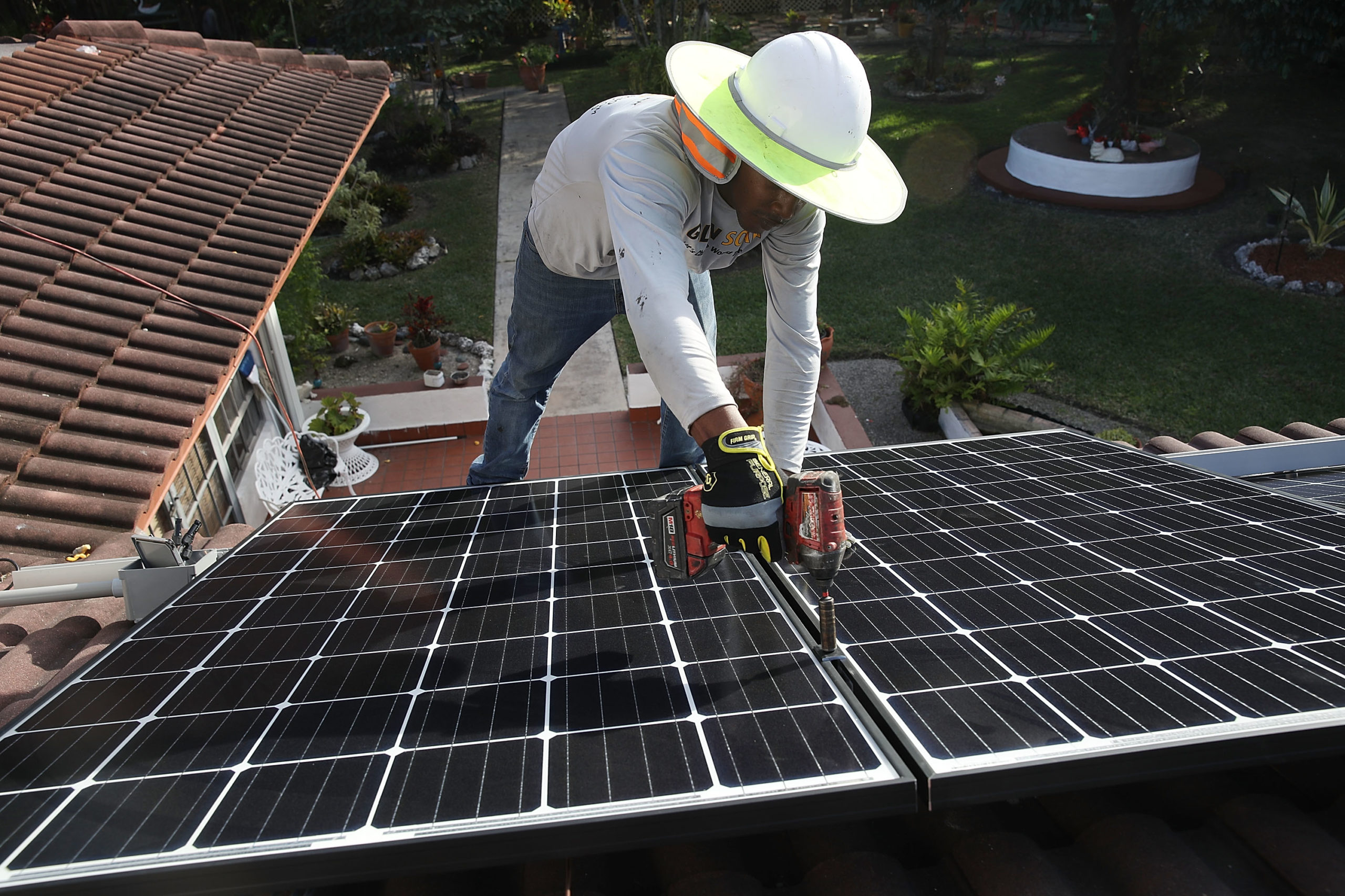 A worker from the Goldin Solar company installs a solar panel system in Palmetto Bay, Florida, in 2018. (Joe Raedle/Getty Images)