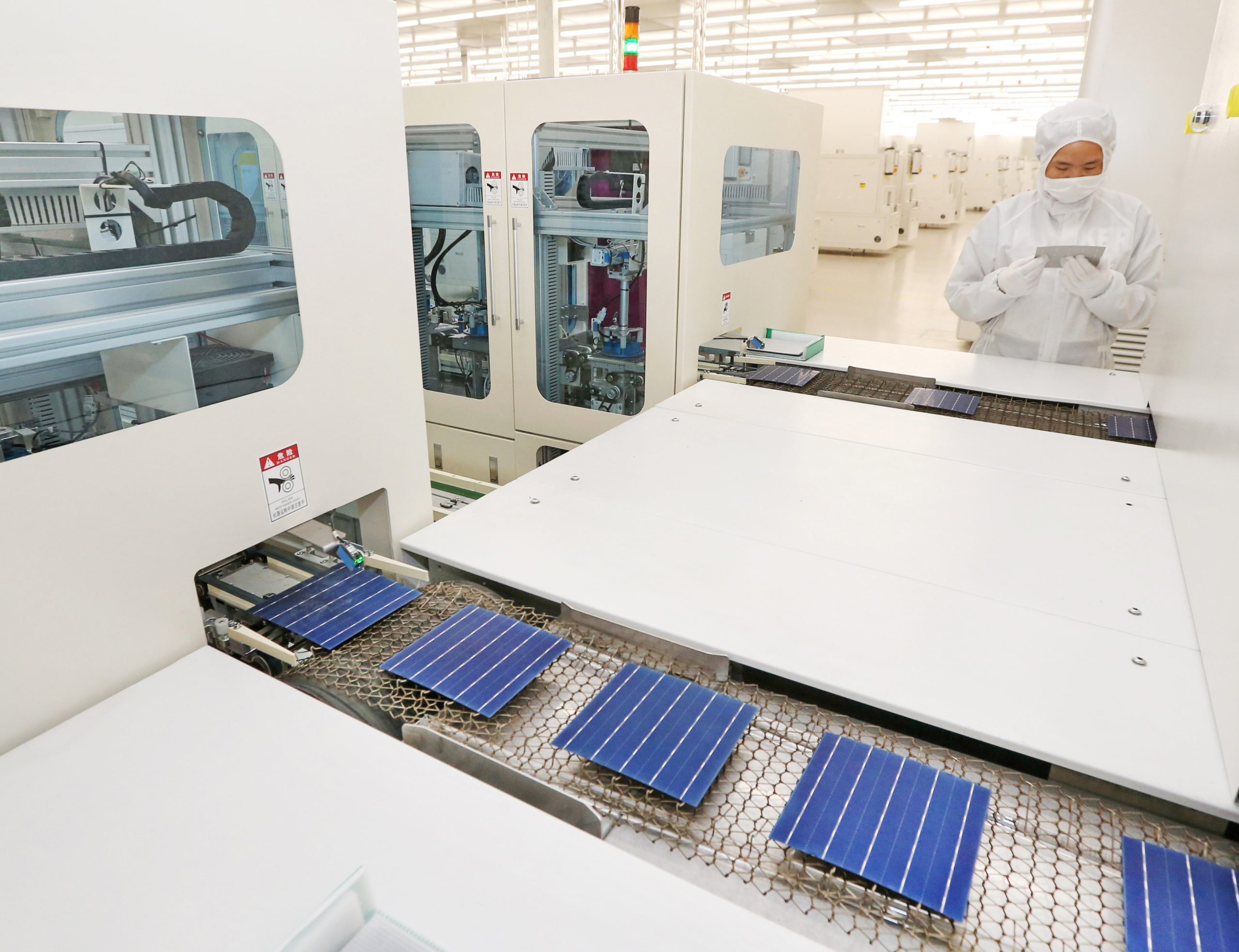 A Chinese worker inspects solar cells at a factory in Nantong on March 28, 2018. (AFP via Getty Images)