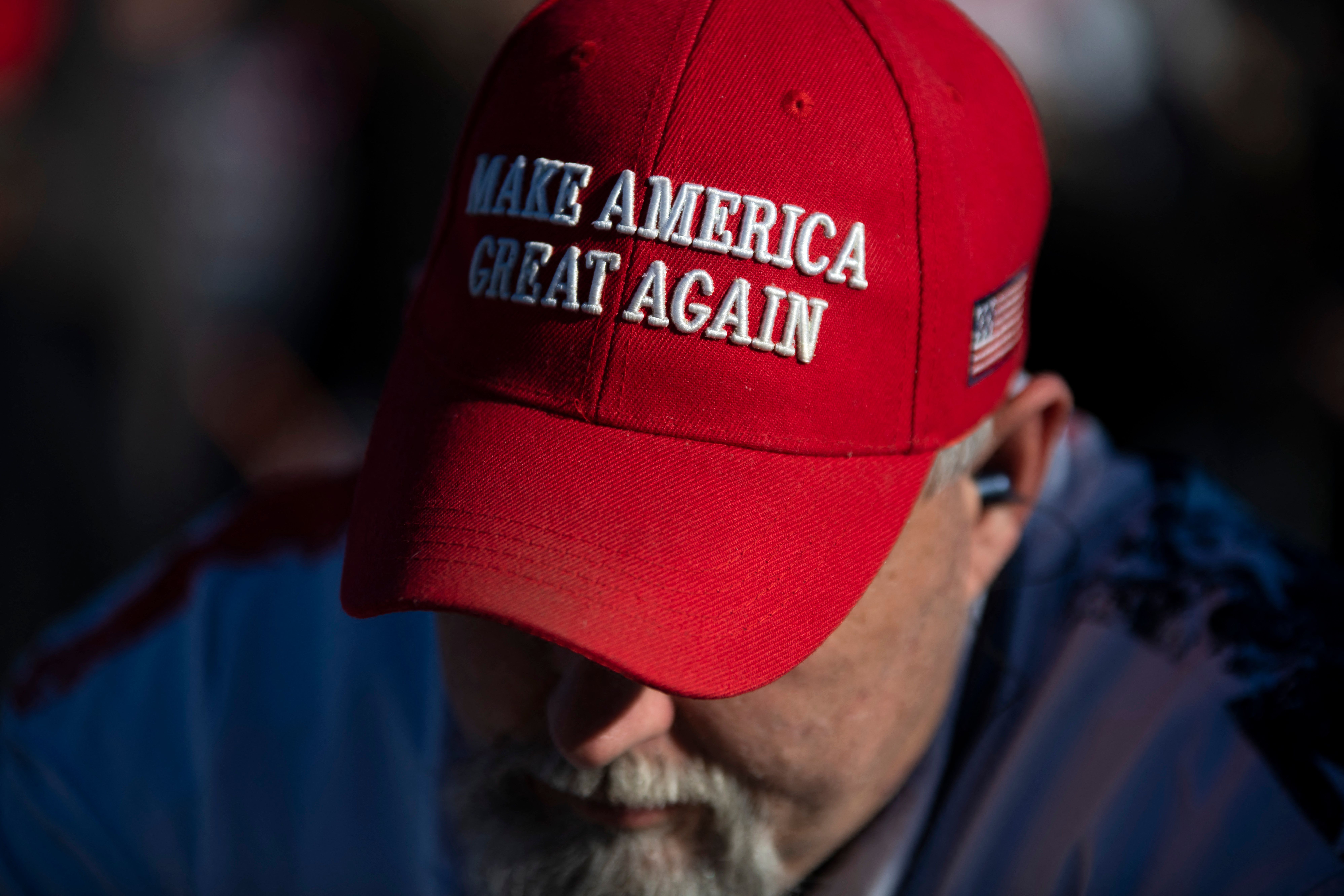 An attendee wearing a MAGA hat waits before former US President Donald Trump speaks during a "Save America" rally in Conroe, Texas on January 29, 2022. (Photo by MARK FELIX/AFP /AFP via Getty Images)