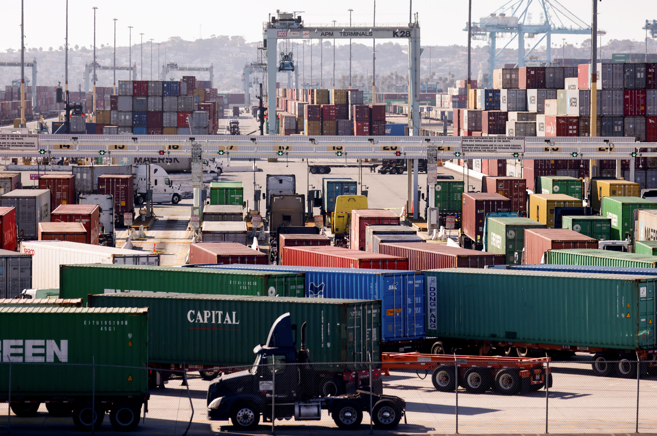 Trucks haul shipping containers at the Port of Los Angeles on November 24, 2021 in San Pedro, California. (Photo by Mario Tama/Getty Images)