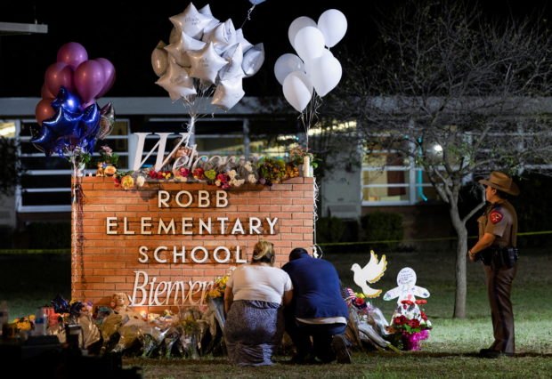 Stephanie and Michael Chavez of San Antonio pay their respects at a makeshift memorial outside Robb Elementary School, the site of a mass shooting, in Uvalde, Texas, U.S., May 25, 2022. REUTERS/Nuri Vallbona TPX IMAGES OF THE DAY