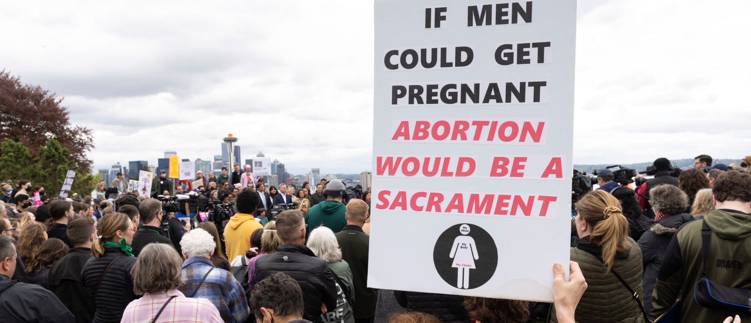 A person holds a sign that reads "if men could get pregnant, abortion would be a sacrament" during a pro-choice rally and press conference with Washington State Governor Jay Inslee and elected officials in Seattle, Washington on May 3, 2022.
