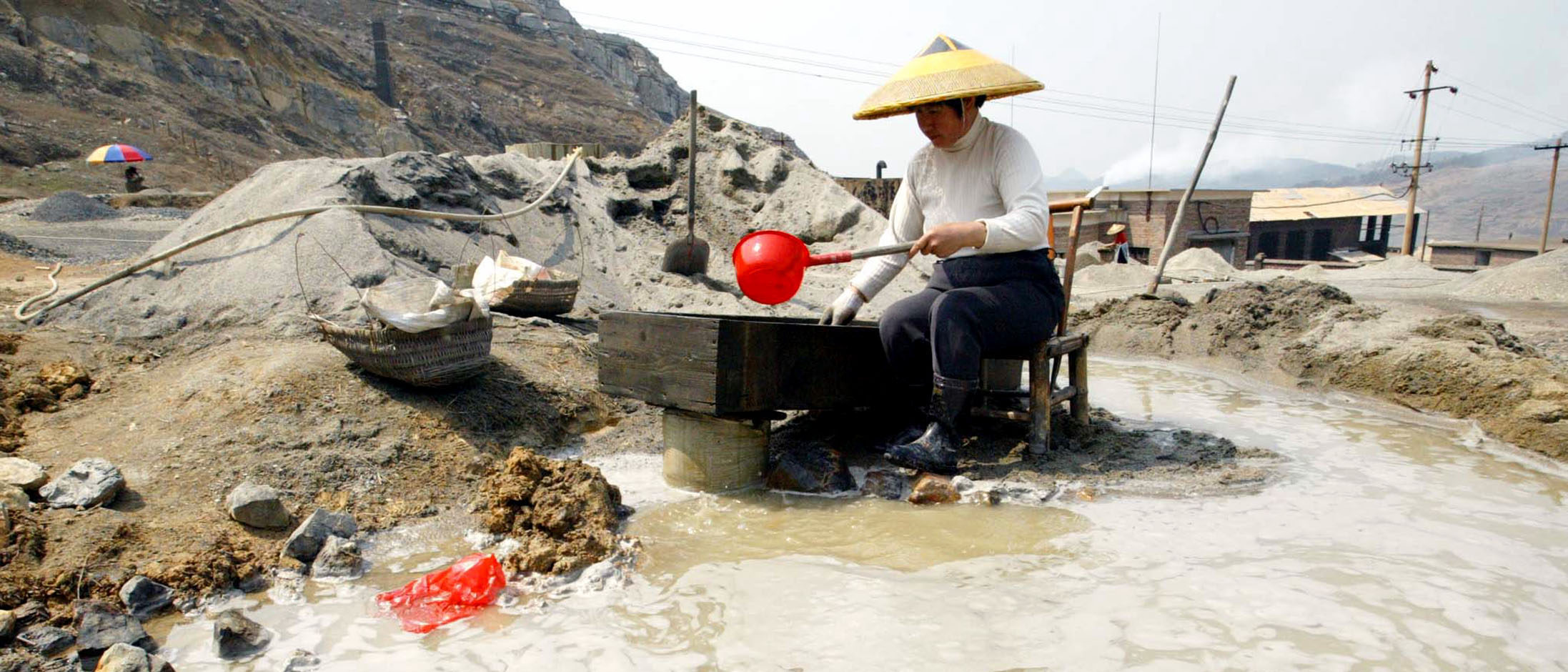 A Chinese villager sifts for antimony at an illegal mine at Lengshuijiang in China's southern province of Hunan August 10, 2003. The environment of Lengshuijiang has deteriorated to an alarming level due to indiscriminate and illegal mining. Antimony was first discovered in Lengshuijiang about 500 years ago and since then the area has developed into probably the world's biggest mining area of antimony, which is widely used in semiconductor technology. (REUTERS/China Photo)