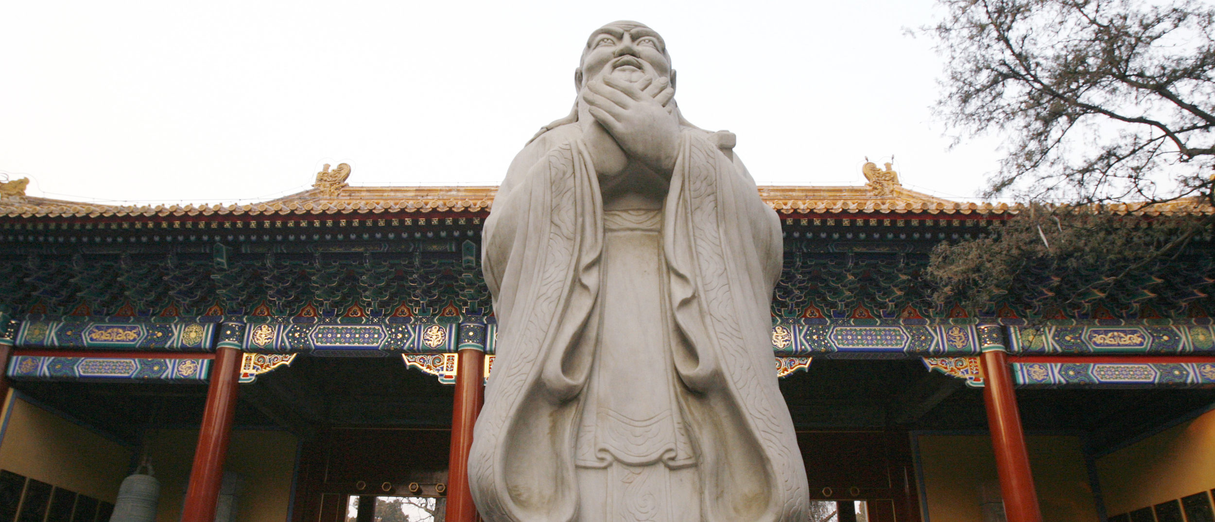 A tour guide speaks beside a statue of Confucius at the Confucian Temple in Beijing December 5, 2007. The Confucian Temple, which is being restored, was first built in Yuan Dynasty of the 14th century and was completed in 1306. The temple was a place where emperors offered national sacrifices to Confucius in the Yuan, Ming, and Qing dynasty. The Ancient Confucian Temple was part of the Guozijian or Imperial College. (REUTERS/Claro Cortes)