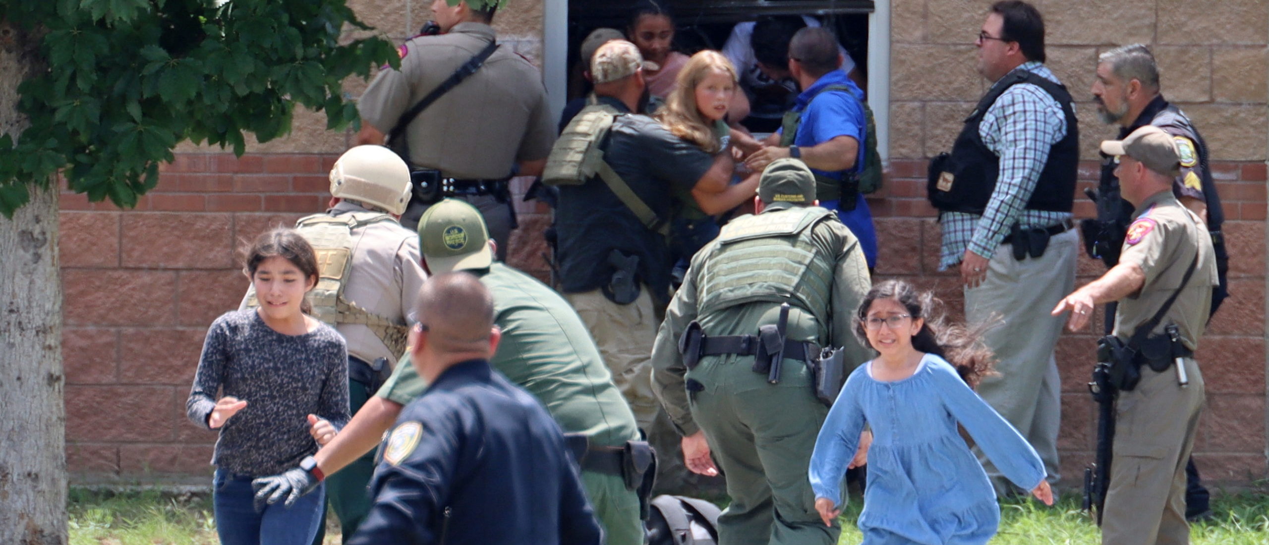 Children run to safety after escaping from a window during a mass shooting at Robb Elementary School where a gunman killed nineteen children and two adults in Uvalde, Texas, U.S. May 24, 2022.