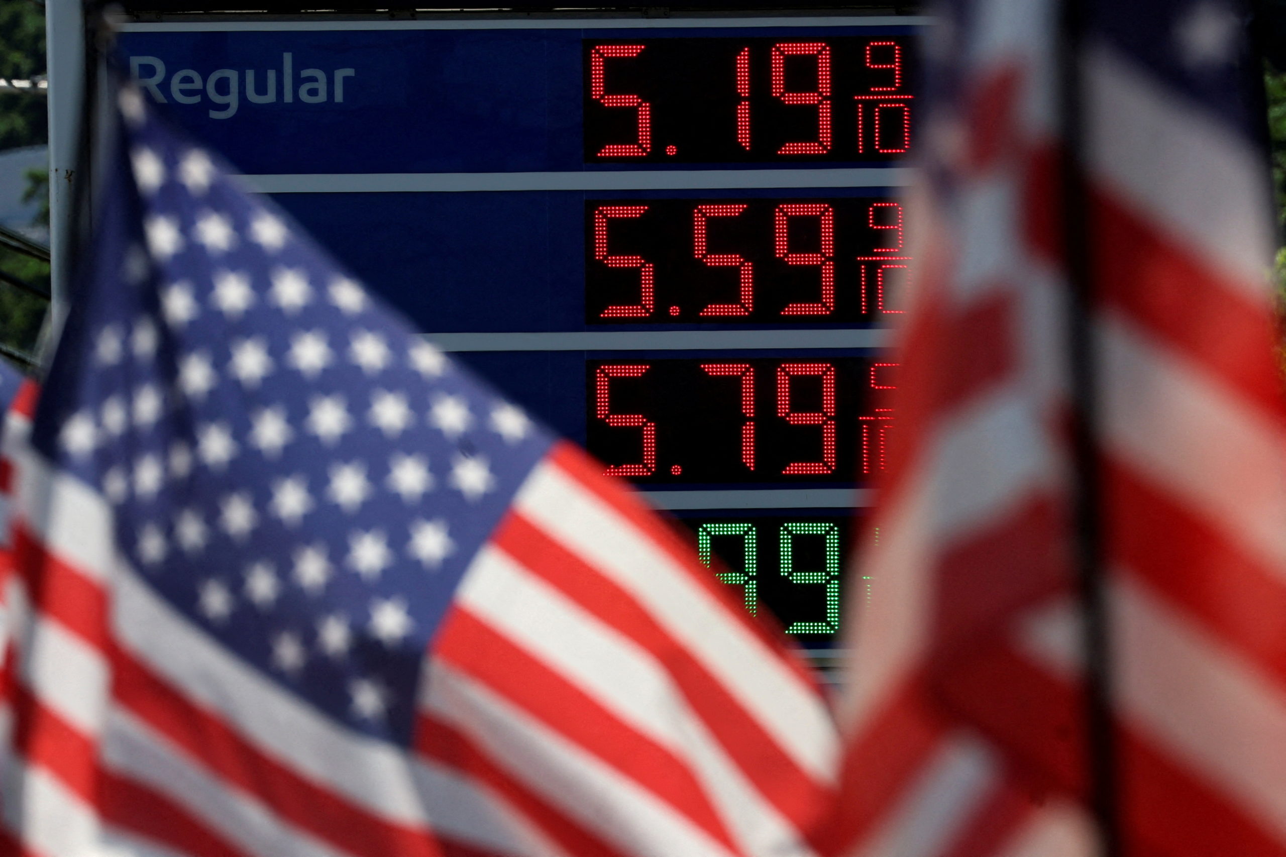 FILE PHOTO: Gasoline prices are displayed at an Exxon gas station behind American flag in Edgewater, New Jersey, U.S., June 14, 2022. REUTERS/Mike Segar/File Photo