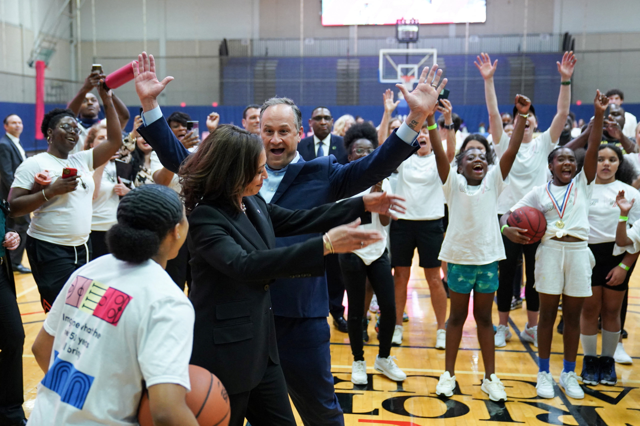 U.S. Vice President Kamala Harris and Second Gentleman Doug Emhoff celebrate after Harris made a successful basket while throwing basketballs with students during the Title IX 50th anniversary field day event at American University in Washington, D.C., U.S., June 22, 2022. REUTERS/Sarah Silbiger