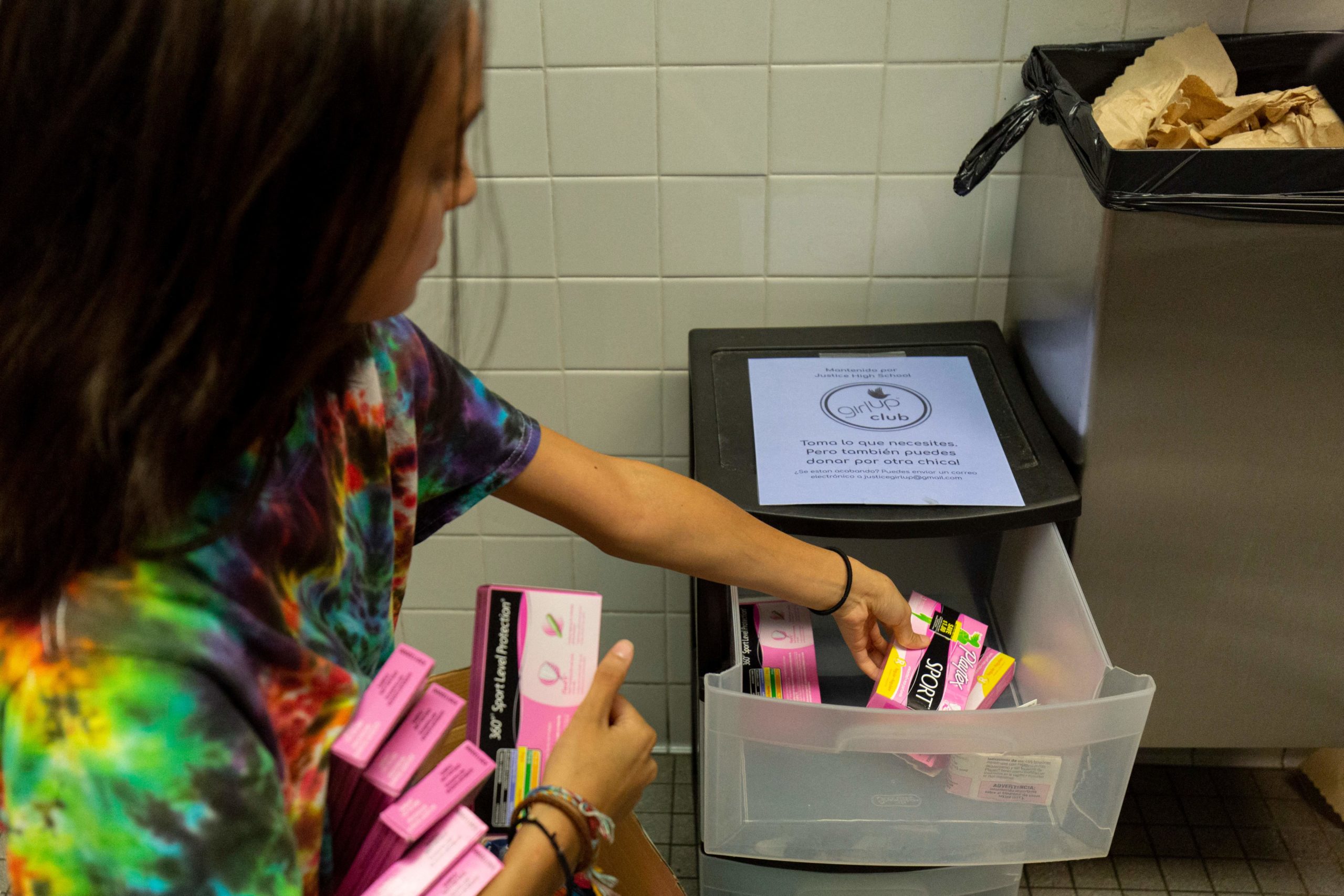 A student of the "Girl Up" club stocks a school bathroom with free pads and tampons to push for menstrual equity, at Justice High School in Falls Church, Virginia, on September 11, 2019. (Photo by Alastair Pike / AFP via Getty Images)