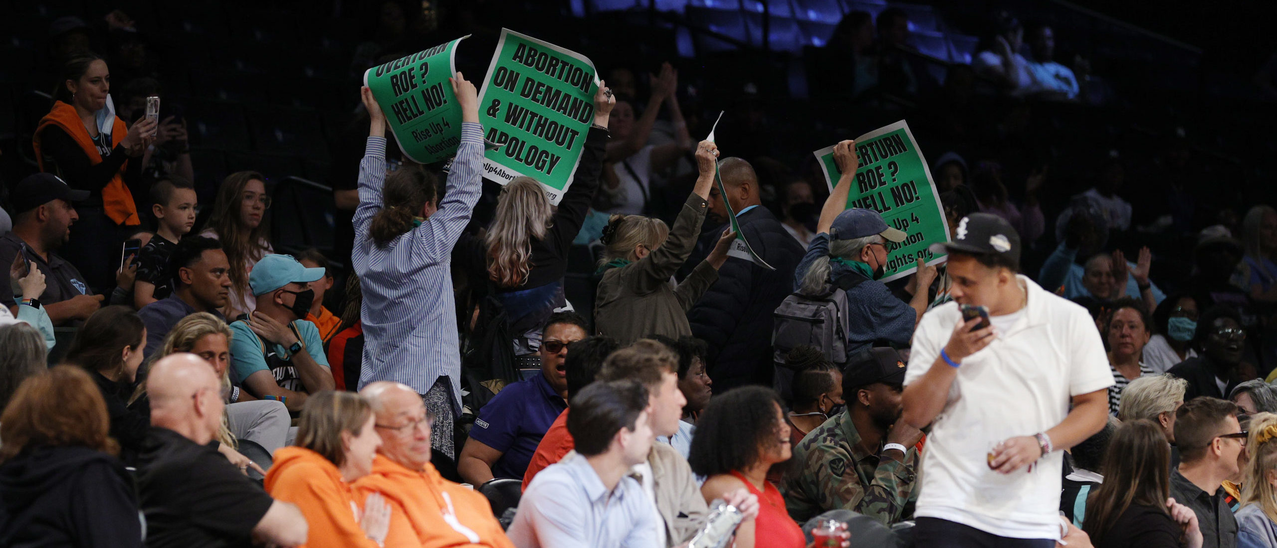 NEW YORK, NEW YORK - JUNE 07: Protestors display signs during the second half between the New York Liberty and the Minnesota Lynx at Barclays Center on June 07, 2022 in the Brooklyn borough of New York City. 