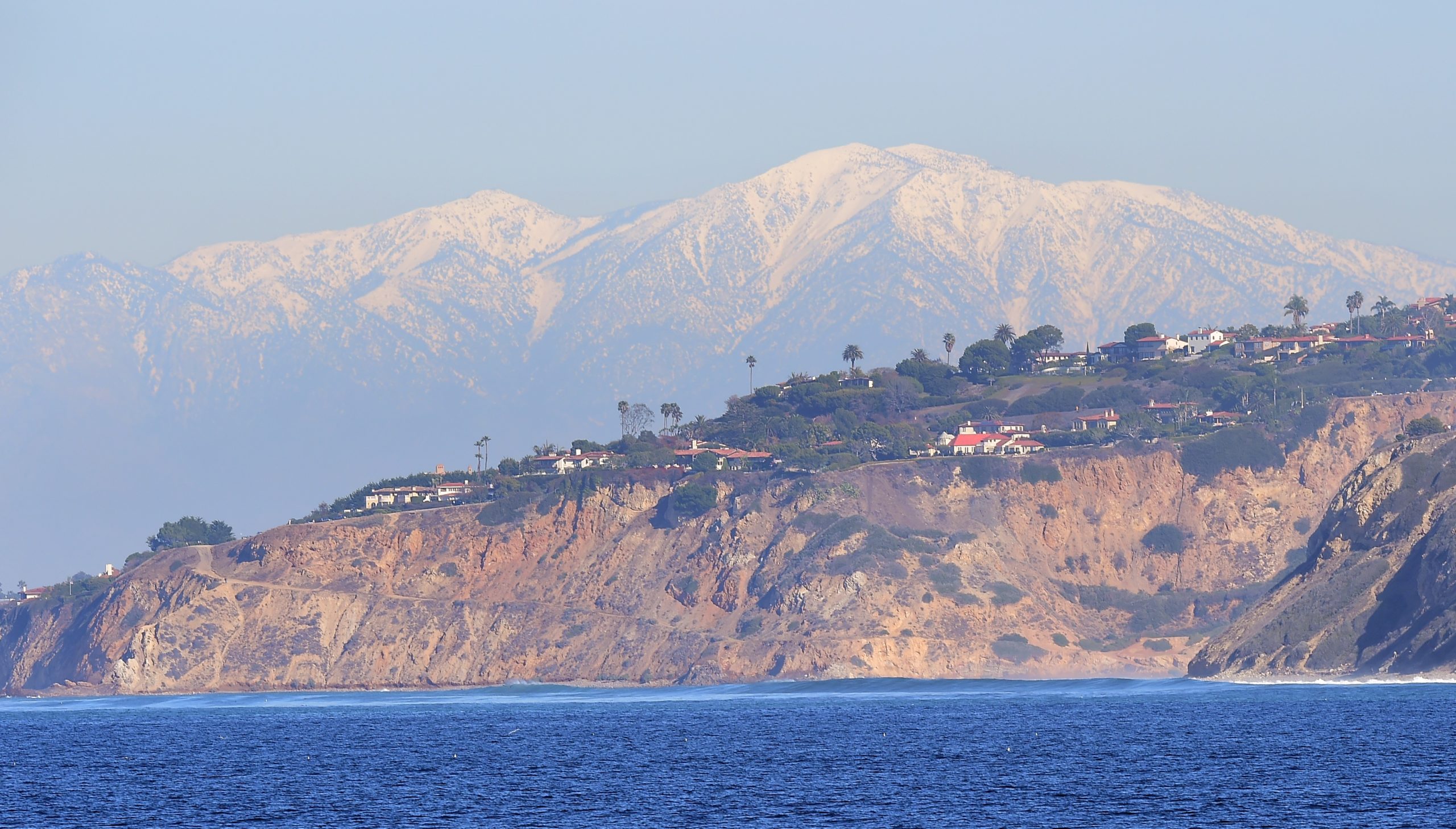 The snow-capped peaks of the San Gabriel Mountains can be seen in the distance from the affluent community of Rancho Palos Verdes on January 12, 2016, where cliffs hug the coastline with hilltop homes offering ocean views of the Pacific Ocean, south of Los Angeles. (Photo: FREDERIC J BROWN/AFP via Getty Images)