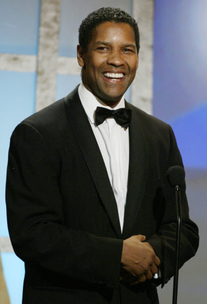 Actor Denzel Washington smiles on stage after accepting his award at the 17th American Cinematheque award dinner in Beverly Hills December 6, 2002 honoring Washington. Washington won the Oscar for best actor for his role in "Training Day" in March 2002. The tribute to Washington will be broadcast on the AMC cable channel in Spring 2003. REUTERS/Fred Prouser FSP/CRB