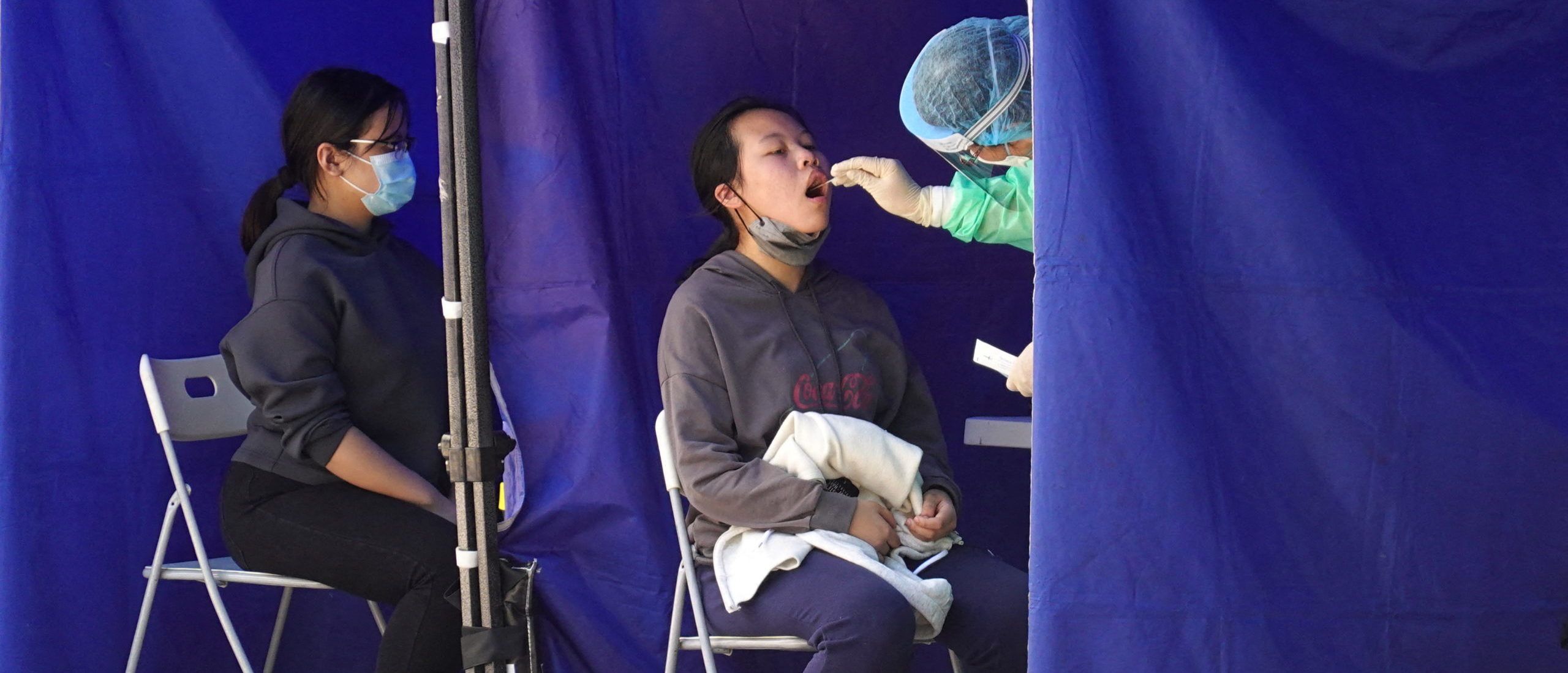 A medical worker takes a swab sample from a person at a makeshift testing site for the coronavirus disease (COVID-19) following the outbreak, in Hong Kong. (REUTERS/Joyce Zhou)