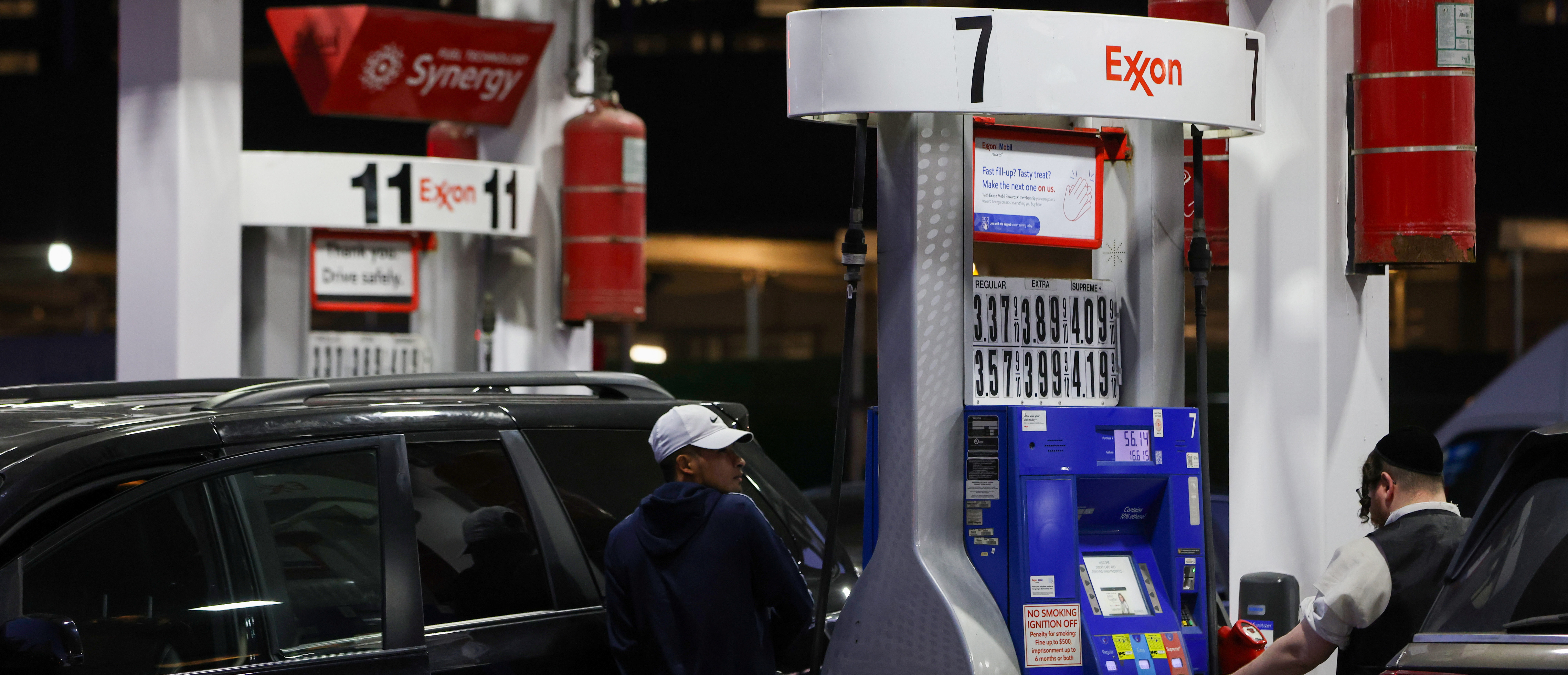 People pump gas at an Exxon gas station in Brooklyn, New York City, U.S., November 23, 2021. REUTERS/Andrew Kelly