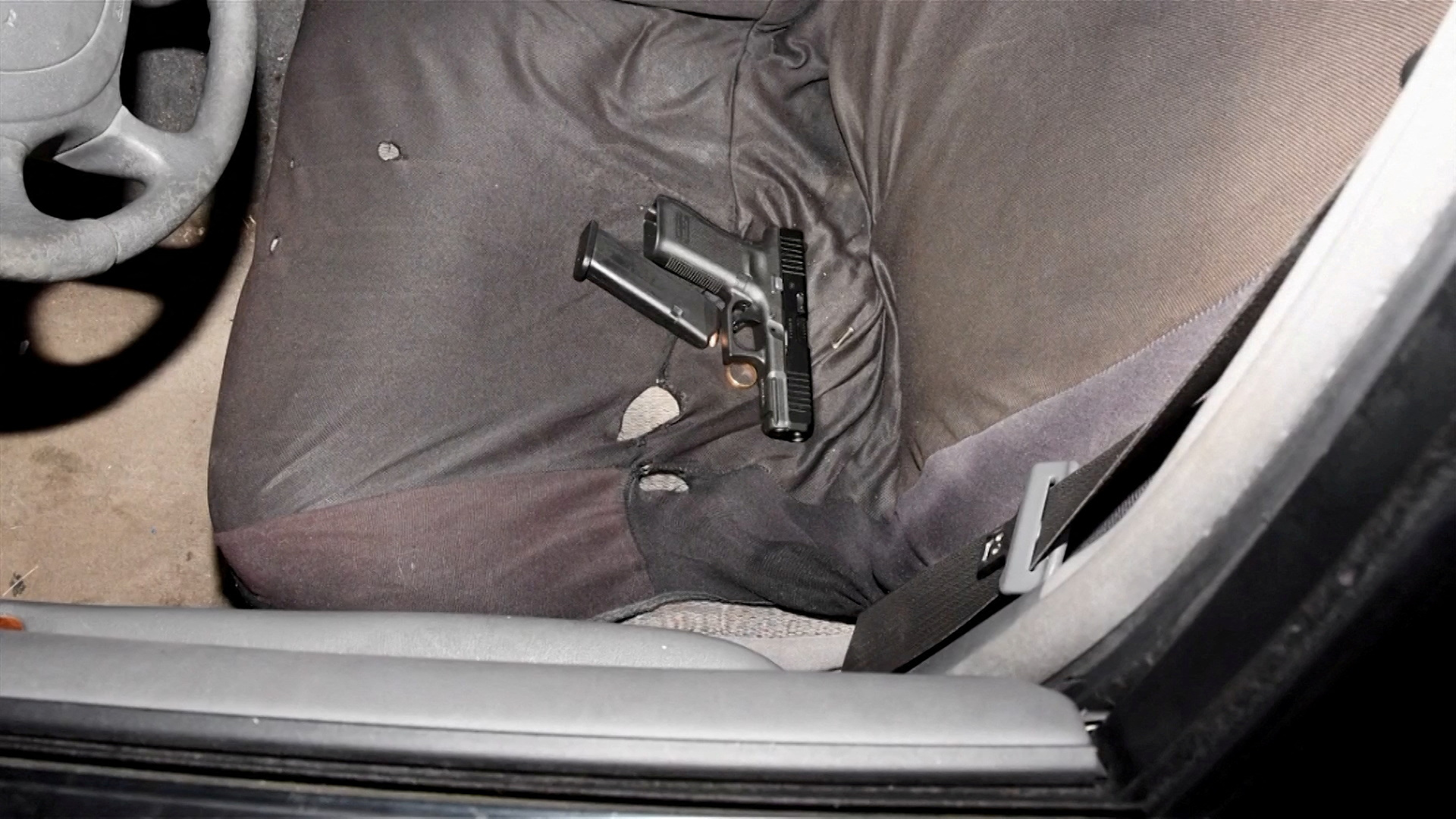 A handgun, loaded magazine and a gold ring are seen on the front seat of the vehicle of Jayland Walker in Akron, Ohio, U.S. June 27, 2022 in a still image from a police video presentation. City of Akron/Handout via REUTERS