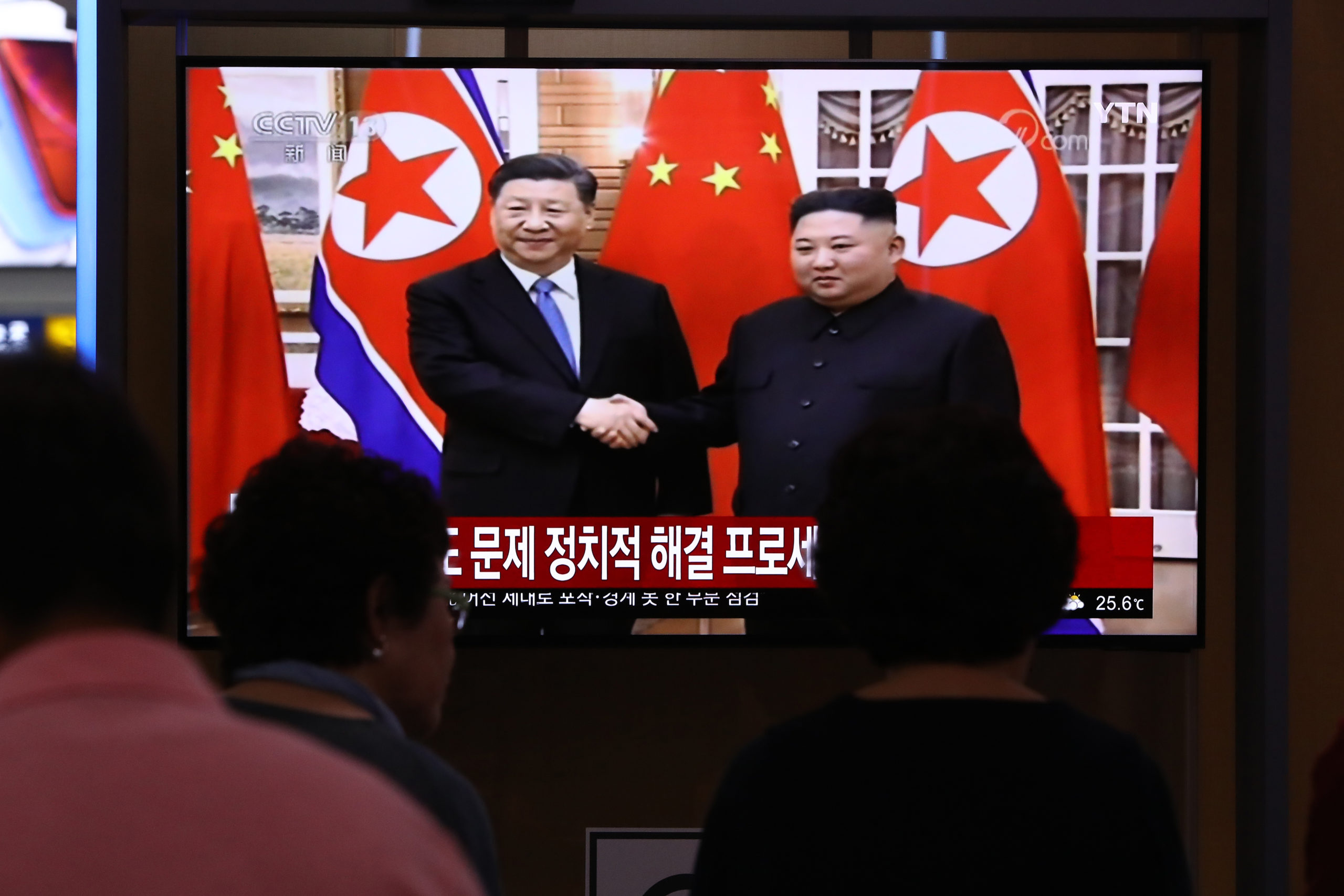 SEOUL, SOUTH KOREA - JUNE 20: South Koreans watch on a screen showing North Korean leader Kim Jong Un shaking hands with Chinese President Xi Jinping at the Seoul Railway Station on June 20, 2019 in Seoul, South Korea. Chinese President Xi Jinping visits to North Korea and he vowed to play a greater role in helping make progress in negotiations on Korean Peninsula issues. (Photo by Chung Sung-Jun/Getty Images)