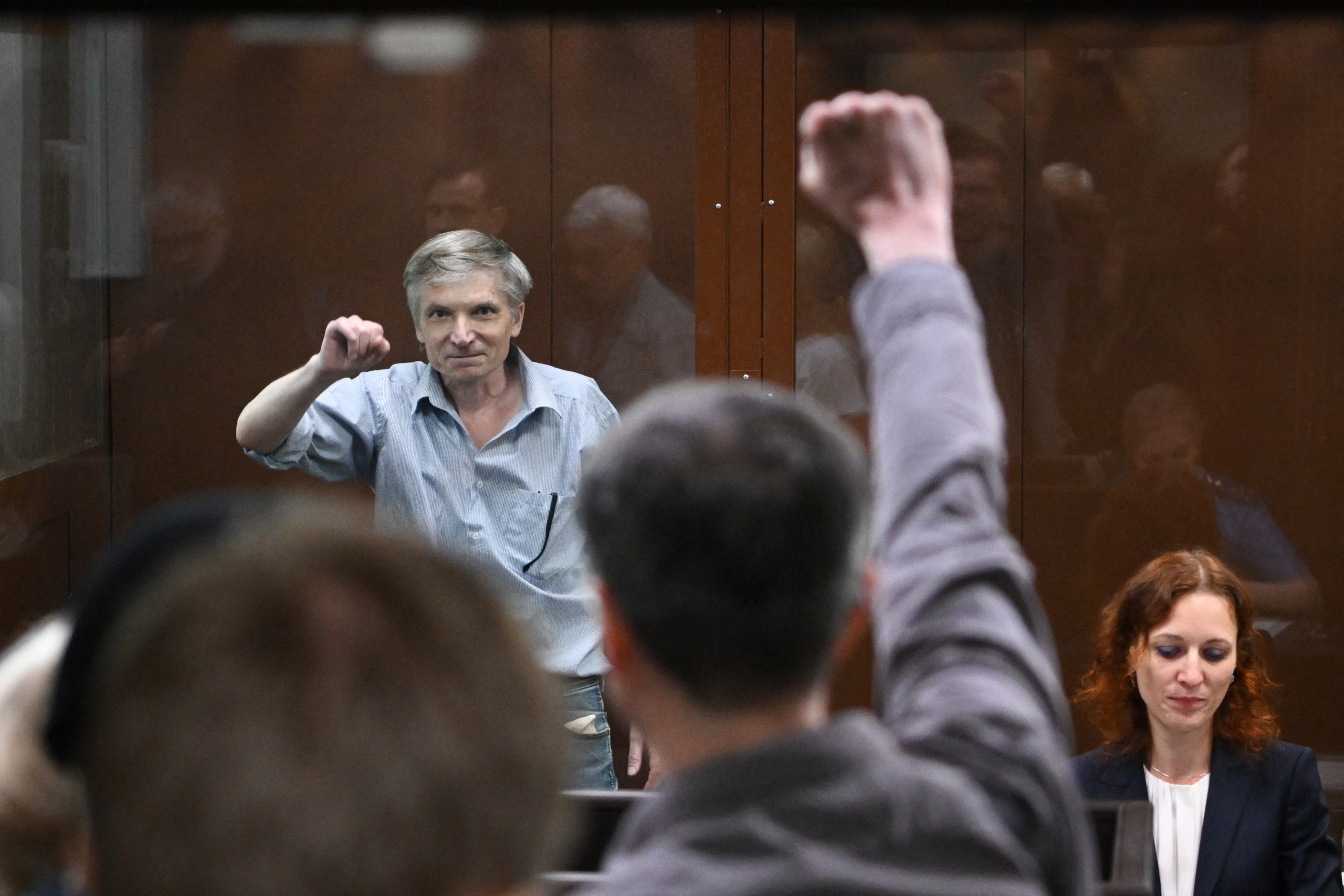 Moscow city deputy Alexei Gorinov, accused of spreading "false information" about the Russian army, gestures inside a glass cell during a hearing in his trial at a courthouse in Moscow on June 21, 2022. (Photo by NATALIA KOLESNIKOVA/AFP via Getty Images)