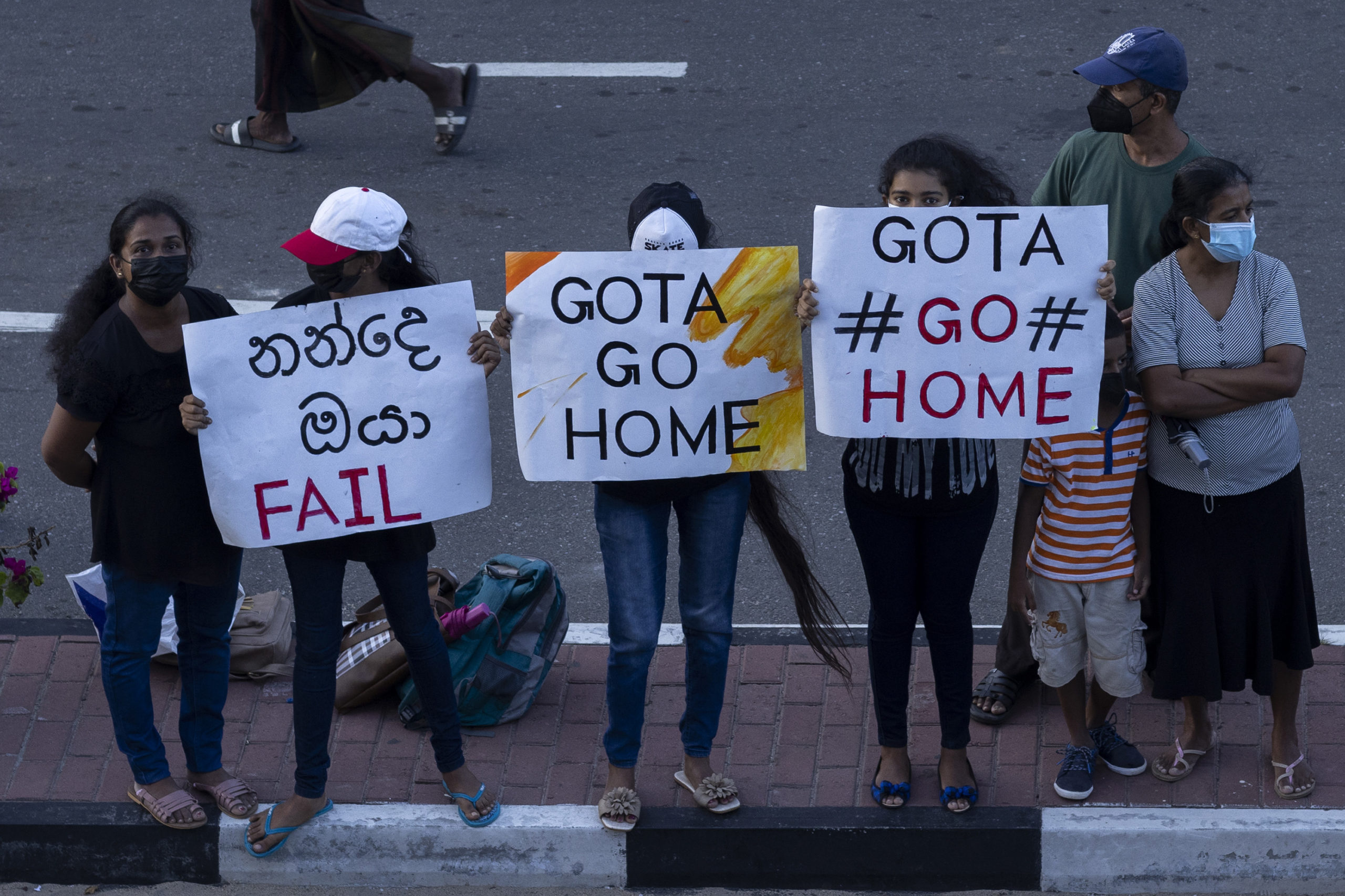 GALLE, SRI LANKA - JULY 09: Anti-government protesters hold placards during protests calling for the resignation of Sri Lanka's President Gotabaya Rajapaksa and Prime Minister Ranil Wickremesinghe on July 09, 2022 in Galle, Sri Lanka. Beleaguered Sri Lankan President Gotabaya Rajapaksa has said he would resign after he fled his official residence in Colombo following thousands of anti-government protesters storming the compound. (Photo by Buddhika Weerasinghe/Getty Images)