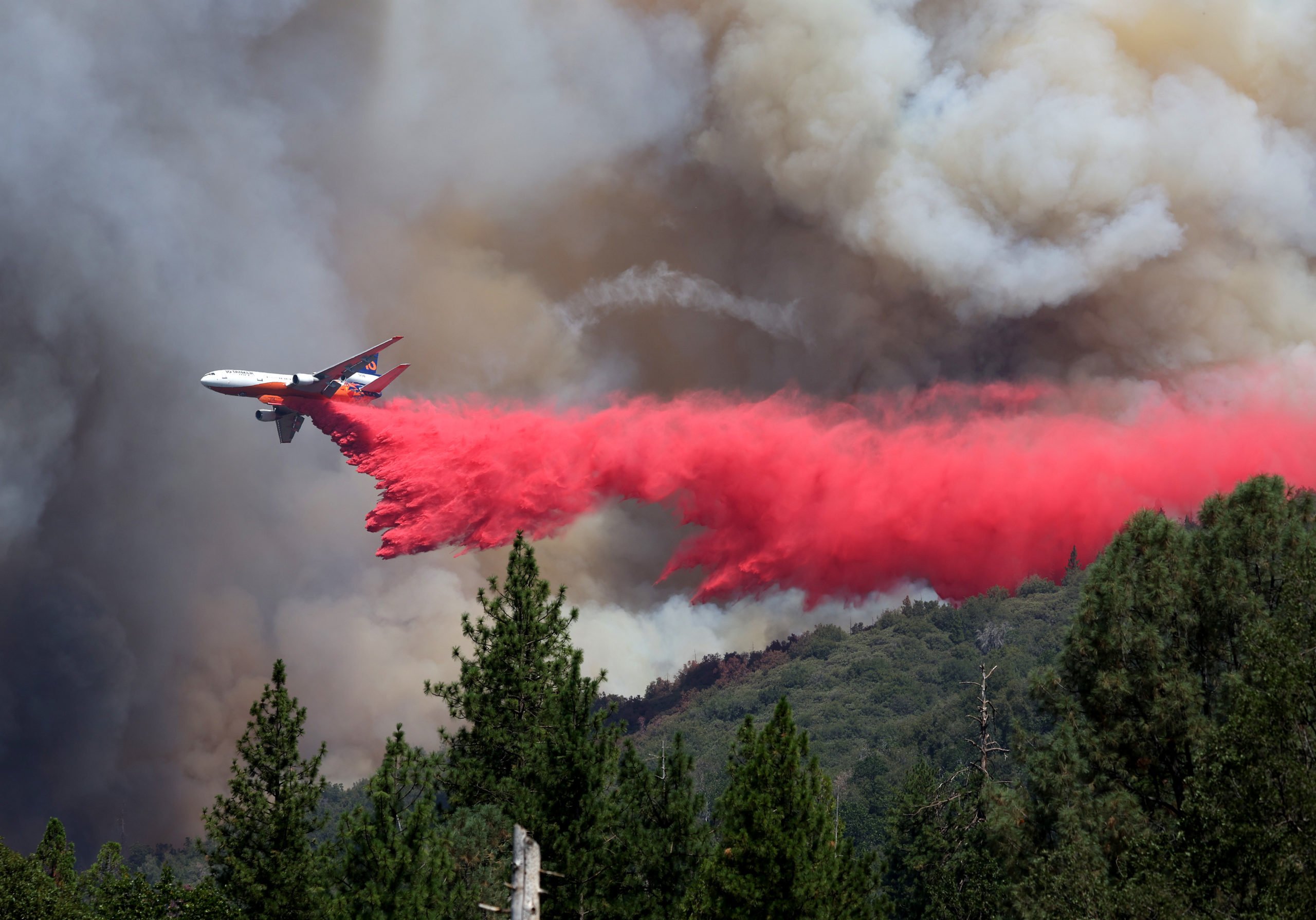JERSEYDALE, CALIFORNIA - JULY 24: A firefighting aircraft drops retardant ahead of the Oak Fire on July 24, 2022 near Jerseydale, California. The fast moving Oak Fire burning outside of Yosemite National Park has forced evacuations, charred over 14,000 acres and has destroyed several homes since starting on Friday afternoon. The fire is zero percent contained. (Photo by Justin Sullivan/Getty Images)