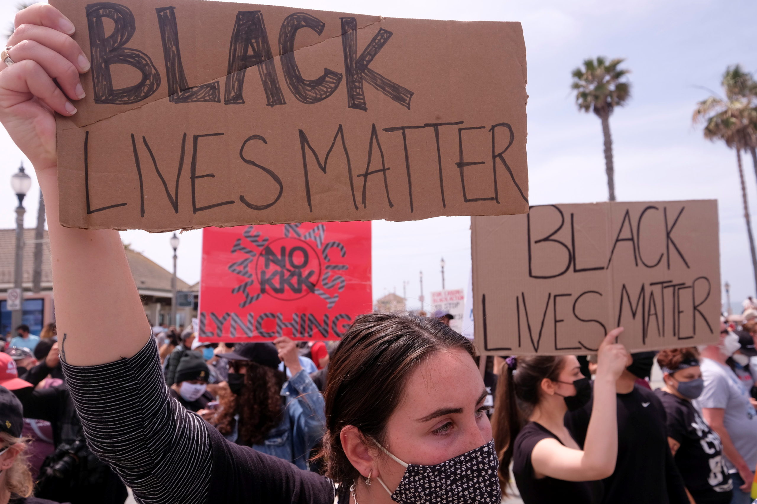 Demonstrators holding signs take part in a Black Lives Matter protest in Huntington Beach, California, U.S. April 11, 2021. REUTERS/Ringo Chiu