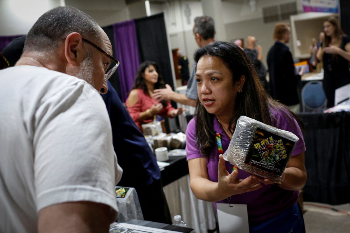 A vendor shows mushroom spores to a visitor during the Cannadelic Miami expo, in Miami, Florida, U.S. February 5, 2022. REUTERS/Marco Bello