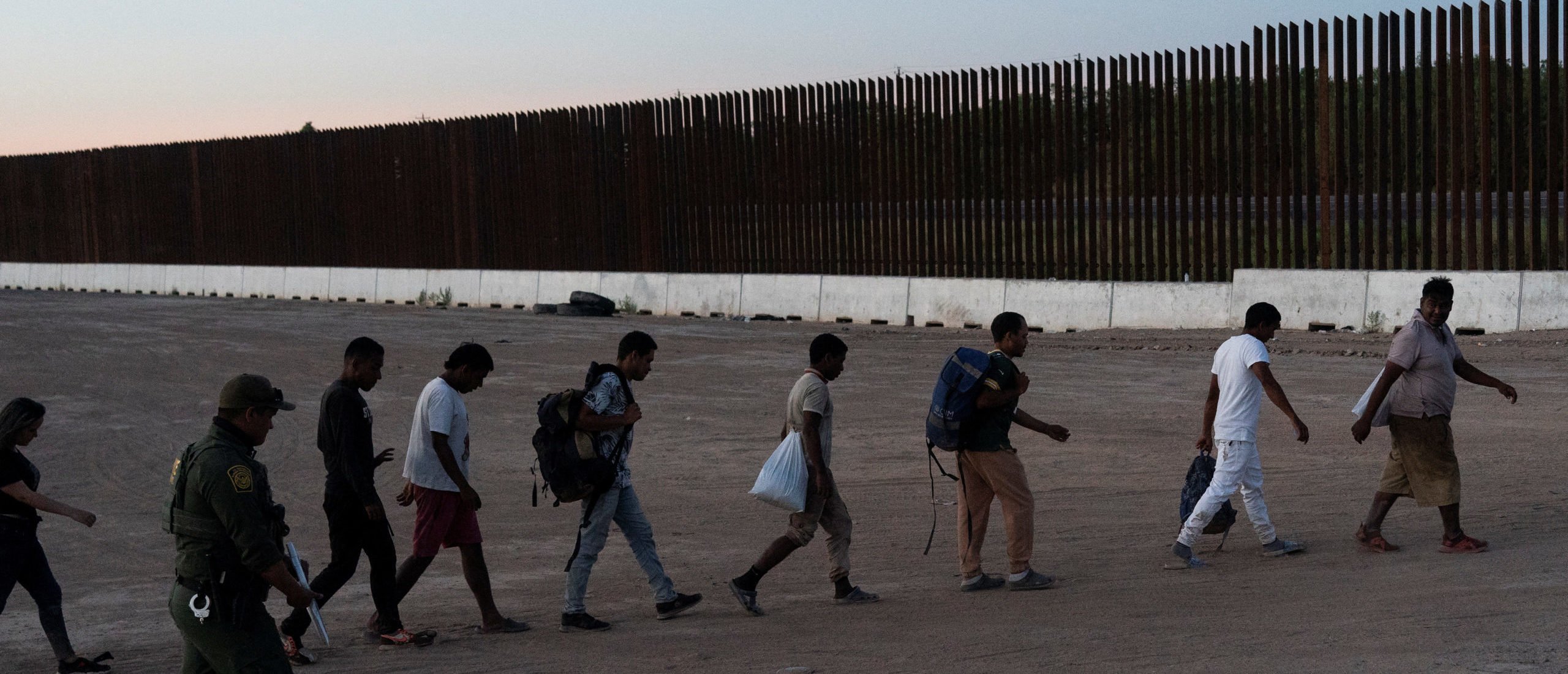 Asylum seeking migrants walk as they are transported by U.S. Customs and Border Protection agents, after crossing Rio Grande river into the U.S. from Mexico, at Eagle Pass, Texas, U.S., July 26, 2022.