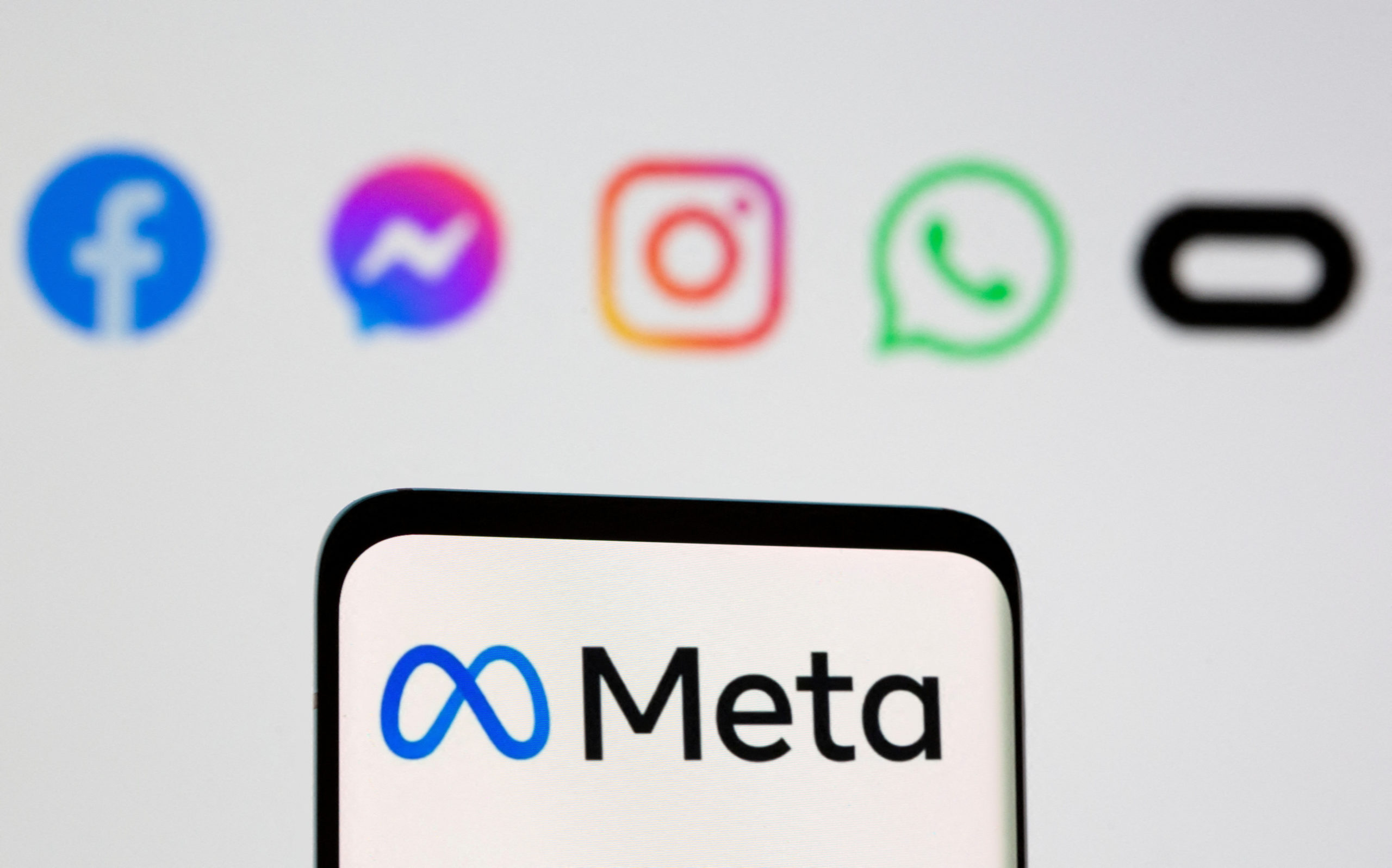 FILE PHOTO: Facebook's new rebrand logo Meta is seen on smartpone in front of displayed logo of Facebook, Messenger, Intagram, Whatsapp, Oculus in this illustration picture taken October 28, 2021. REUTERS/Dado Ruvic/Illustration