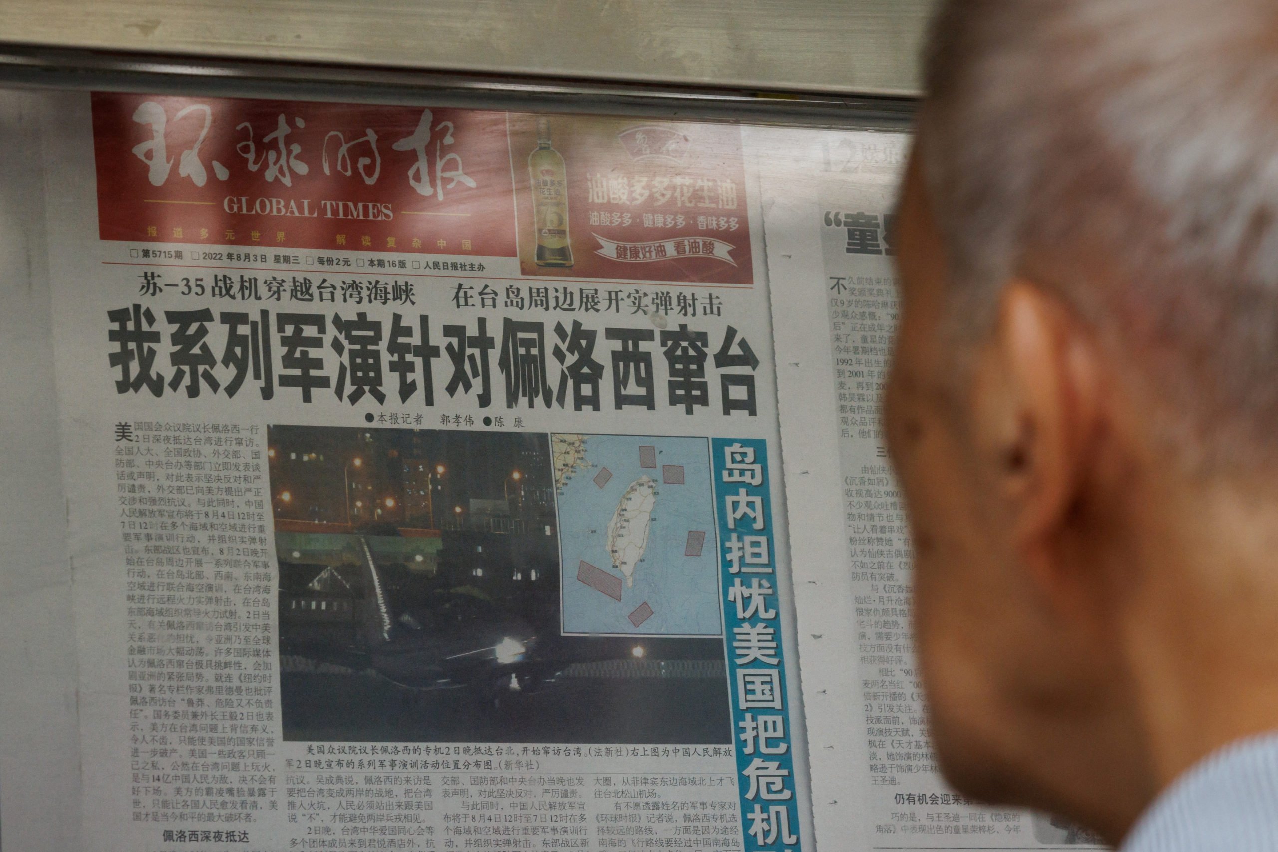 A man reads a Global Times article about military exercises by the Chinese People's Liberation Army (PLA) following U.S. House of Representatives Speaker Nancy Pelosi's Taiwan visit, at a newspaper stand in Beijing, China, August 4, 2022. REUTERS/Thomas Peter