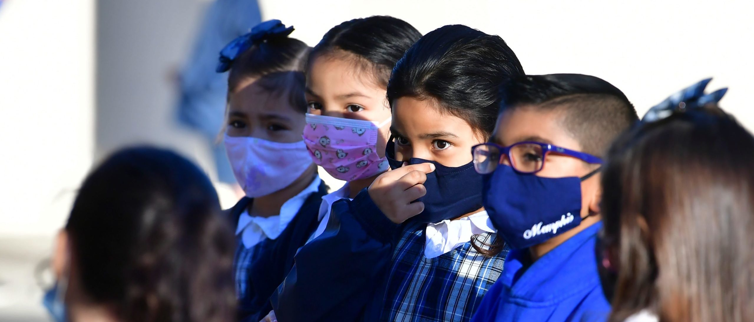 A students adjusts her facemask at St. Joseph Catholic School in La Puente, California on November 16, 2020, where pre-kindergarten to Second Grade students in need of special services returned to the classroom today for in-person instruction. - The campus is the second Catholic school in Los Angeles County to receive a waiver approval to reopen as the coronavirus pandemic rages on. The US surpassed 11 million coronavirus cases Sunday, adding one million new cases in less than a week, according to a tally by Johns Hopkins University. (Photo by Frederic J. BROWN / AFP) (Photo by FREDERIC J. BROWN/AFP via Getty Images)