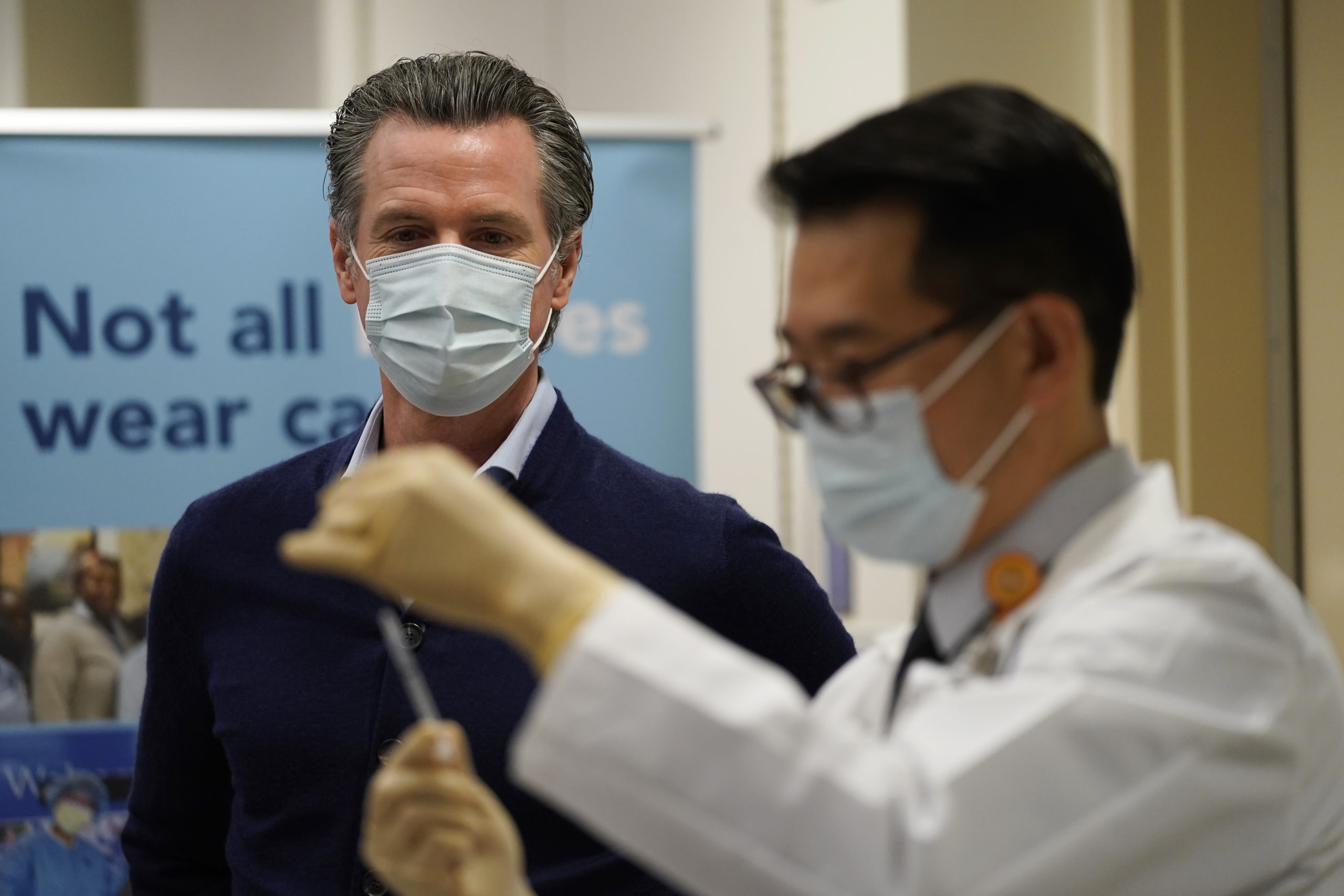 Governor Gavin Newsom watches as the Pfizer-BioNTech COVID-19 vaccine is prepared by Director of Inpatient Pharmacy David Cheng at Kaiser Permanente Los Angeles Medical Center in Los Angeles, California on December 14, 2020. - The United States kicked off a mass vaccination drive Monday hoping to turn the tide on the world's biggest coronavirus outbreak, as the country's death toll neared a staggering 300,000. JAE HONG/POOL/AFP via Getty Images