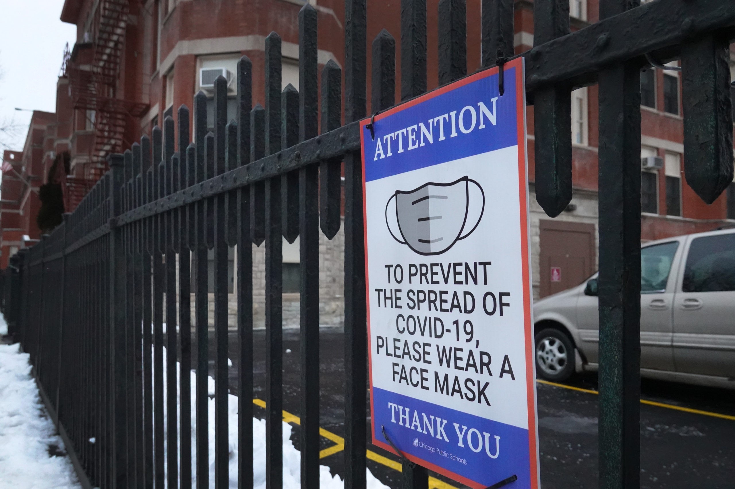 A sign on the fence outside of Lowell elementary school asks students, staff and visitors to wear a mask to prevent the spread of COVID-19 on January 05, 2022 in Chicago, Illinois. Classes at all of Chicago public schools have been canceled today by the school district after the teacher's union voted to return to virtual learning, citing unsafe conditions in the schools as the Omicron variant of the coronavirus continues to spread. (Photo by Scott Olson/Getty Images)