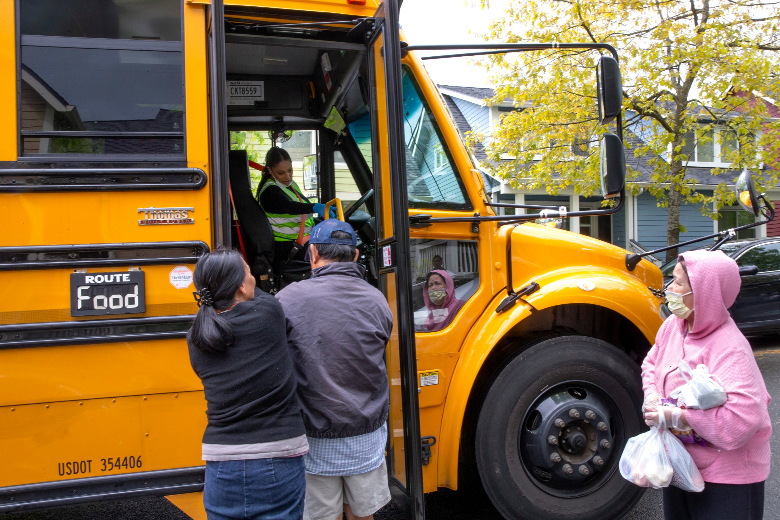 Bus driver Treva White delivers meals to children and their families on May 6, 2020 in Seattle, Washington. Since the outbreak of COVID-19 and the closure of all school buildings, the Seattle Public Schools Nutrition Services Department has been distributing breakfast and lunch to students through a network of 26 school sites and 43 bus routes five days a week. The meal distribution also includes additional food for weekends. Approximately 6,500 people are served per day through the program. (Photo by Karen Ducey/Getty Images)