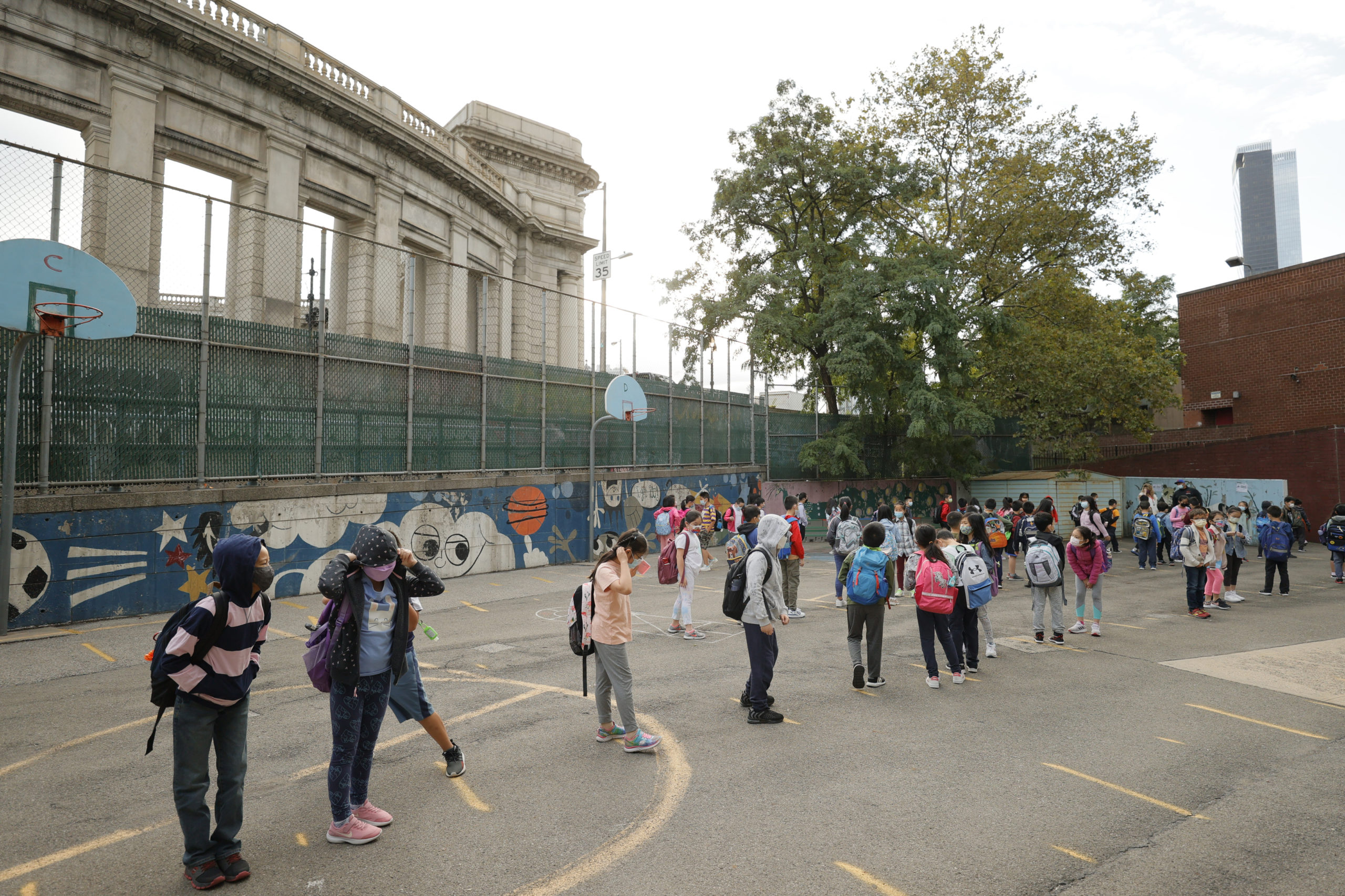 Students line up in the morning at Yung Wing School P.S. 124 on September 27, 2021 in New York City. New York City schools fully reopened earlier this month with all in-person classrooms and mandatory masks on students. The city's mandate ordering all New York City school staff to be vaccinated by midnight today was delayed again after a federal appeals court issued a temporary injunction three days before the mayor's deadline. (Photo by Michael Loccisano/Getty Images)