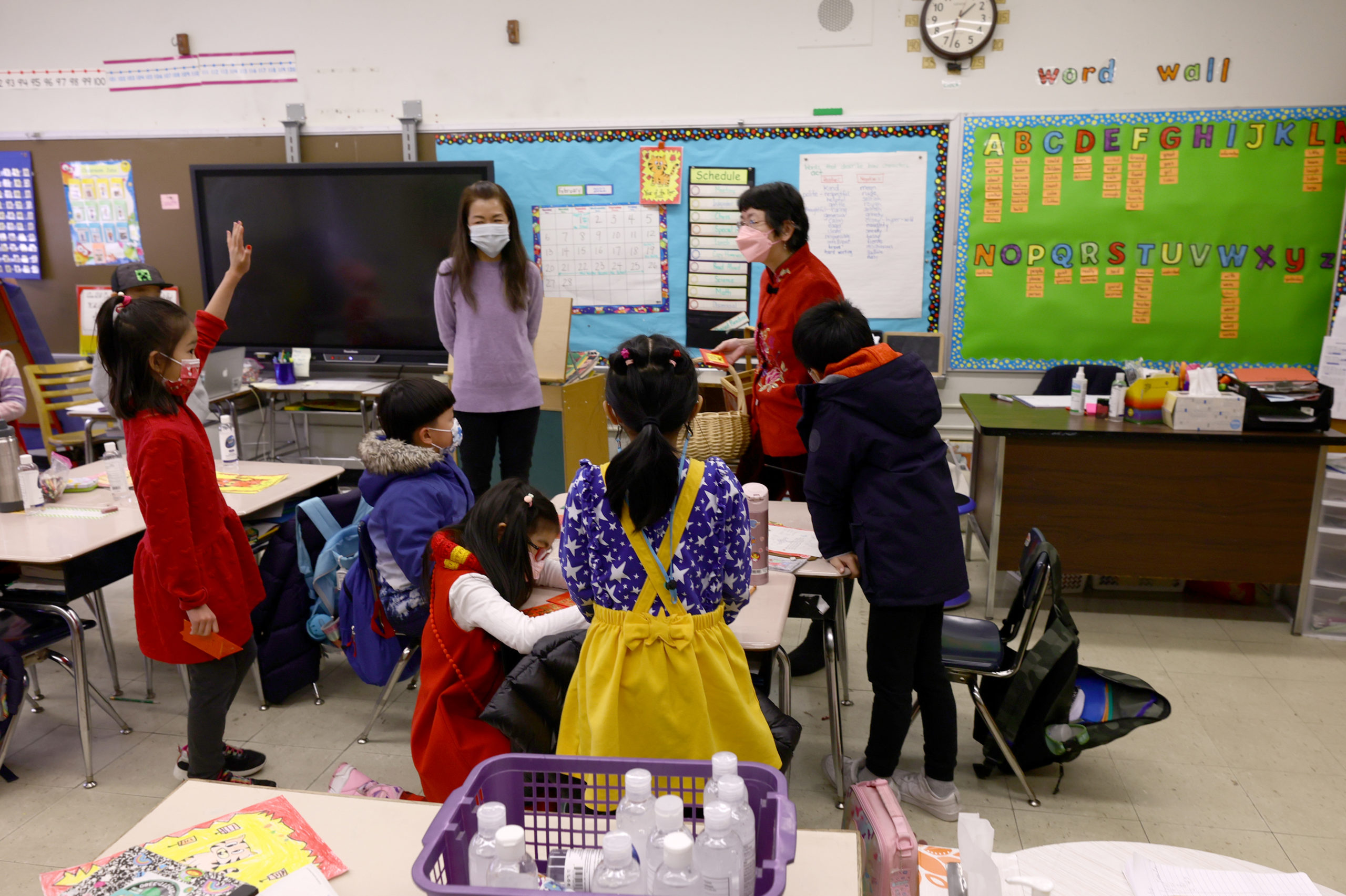Taking a break from handing out red envelopes and candy in a cultural celebration of the Lunar New Year, Principal Alice Hom talks with schoolteacher Sau Sheung Lau at Yung Wing School P.S. 124 on February 02, 2022 in New York City. NYC schools were closed yesterday in observance of what is considered the most important day in the Chinese calendar with the start of the New Year. This event is not only relevant in Asia, but also in other countries where this Chinese tradition is respected and celebrated and is on the table to become the next US Federal Holiday. (Photo by Michael Loccisano/Getty Images)