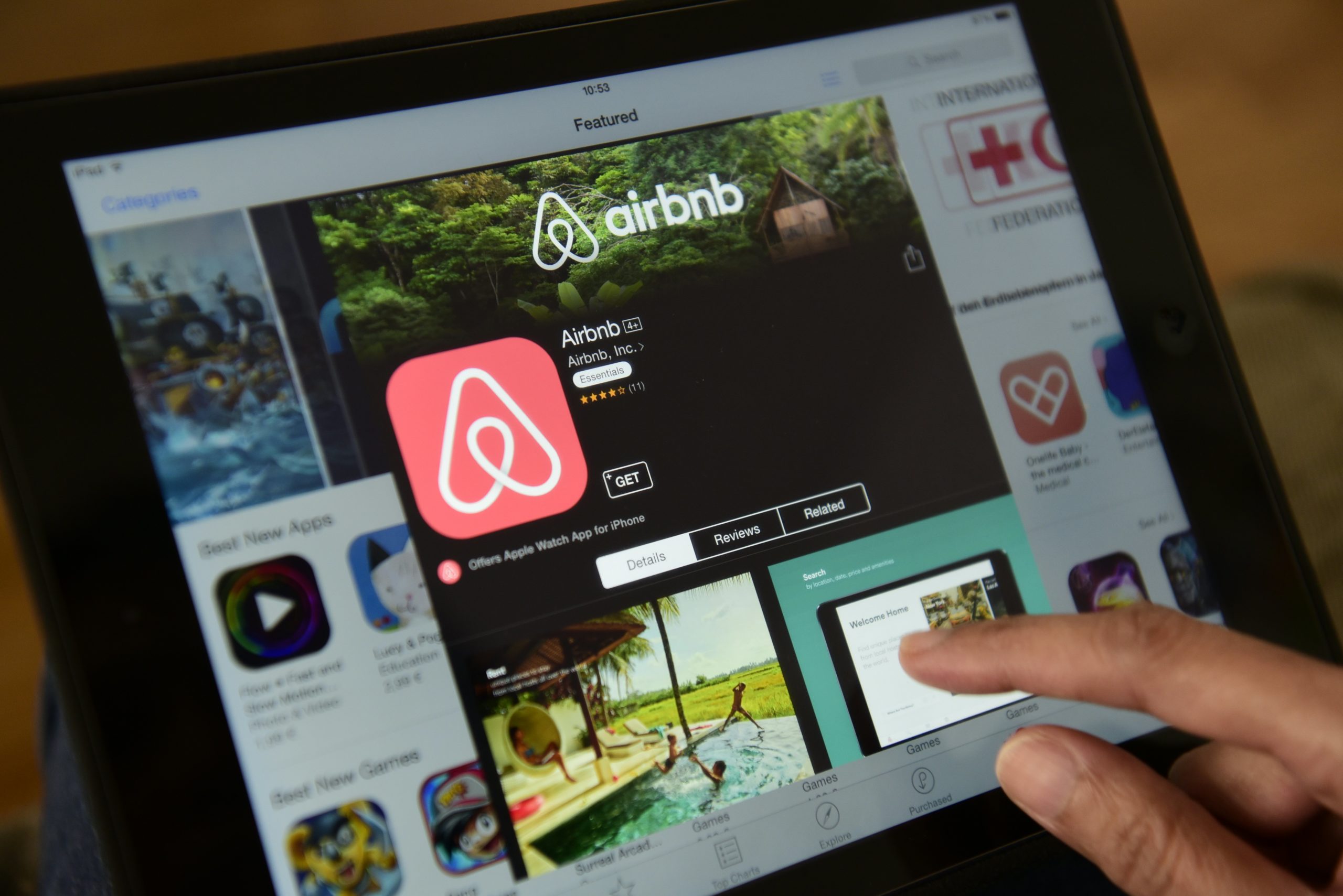 A woman browses the site of US home sharing giant Airbnb on a tablet in Berlin on April 28, 2016. - Berlin will from Sunday, May 1, 2016, restrict private property rentals through Airbnb and similar online platforms, threatening hefty fines in a controversial move meant to keep housing affordable for locals. (Photo by John MACDOUGALL / AFP) 