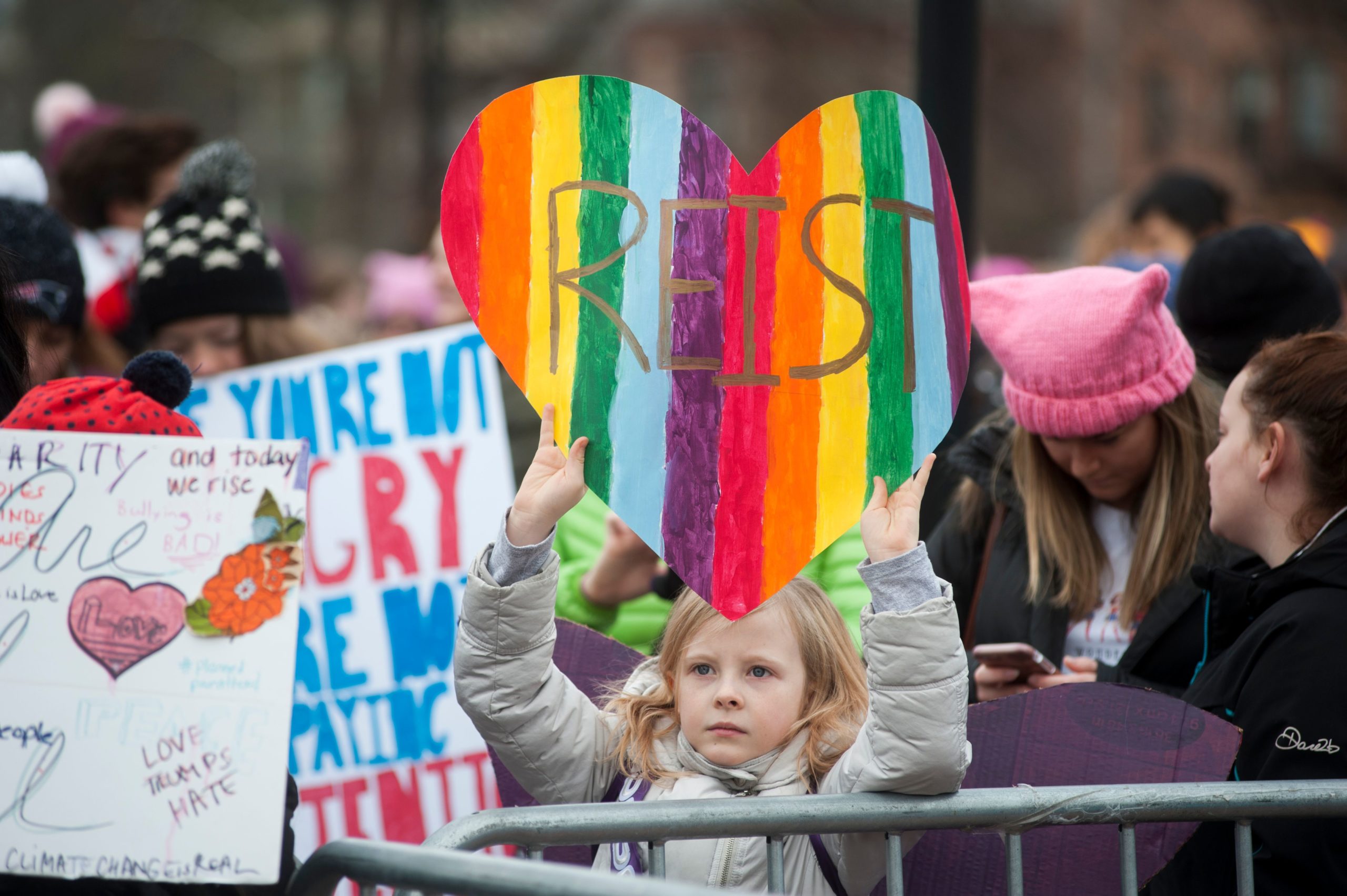 A girl holds up a sign during a rally attended by thousands of demonstrators at Cambridge Commons in Cambridge, Massachusetts on January 20, 2018, celebrating the one-year anniversary of the Women's March, when millions marched around the world in protest of US President Donald Trump's inauguration. / AFP PHOTO / RYAN MCBRIDE (Photo credit should read RYAN MCBRIDE/AFP via Getty Images)