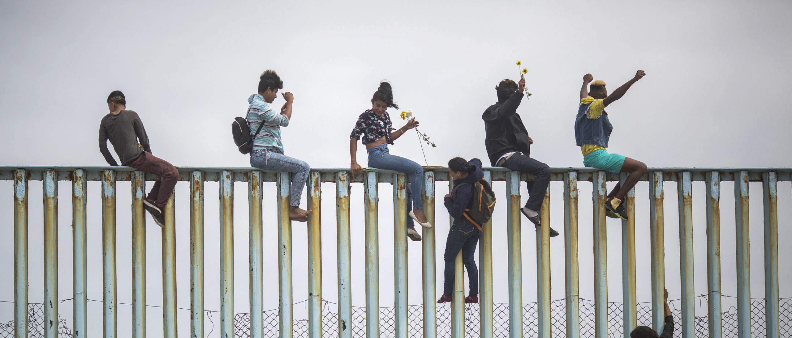 TIJUANA, MEXICO - APRIL 29: People climb a section of border fence to look toward supporters in the U.S. as members of a caravan of Central American asylum seekers arrive to a rally on April 29, 2018 in Tijuana, Baja California Norte, Mexico. More than 300 immigrants, the remnants of a caravan of Central Americans that journeyed across Mexico to ask for asylum in the United States, have reached the border to apply for legal entry. (Photo by David McNew/Getty Images)
