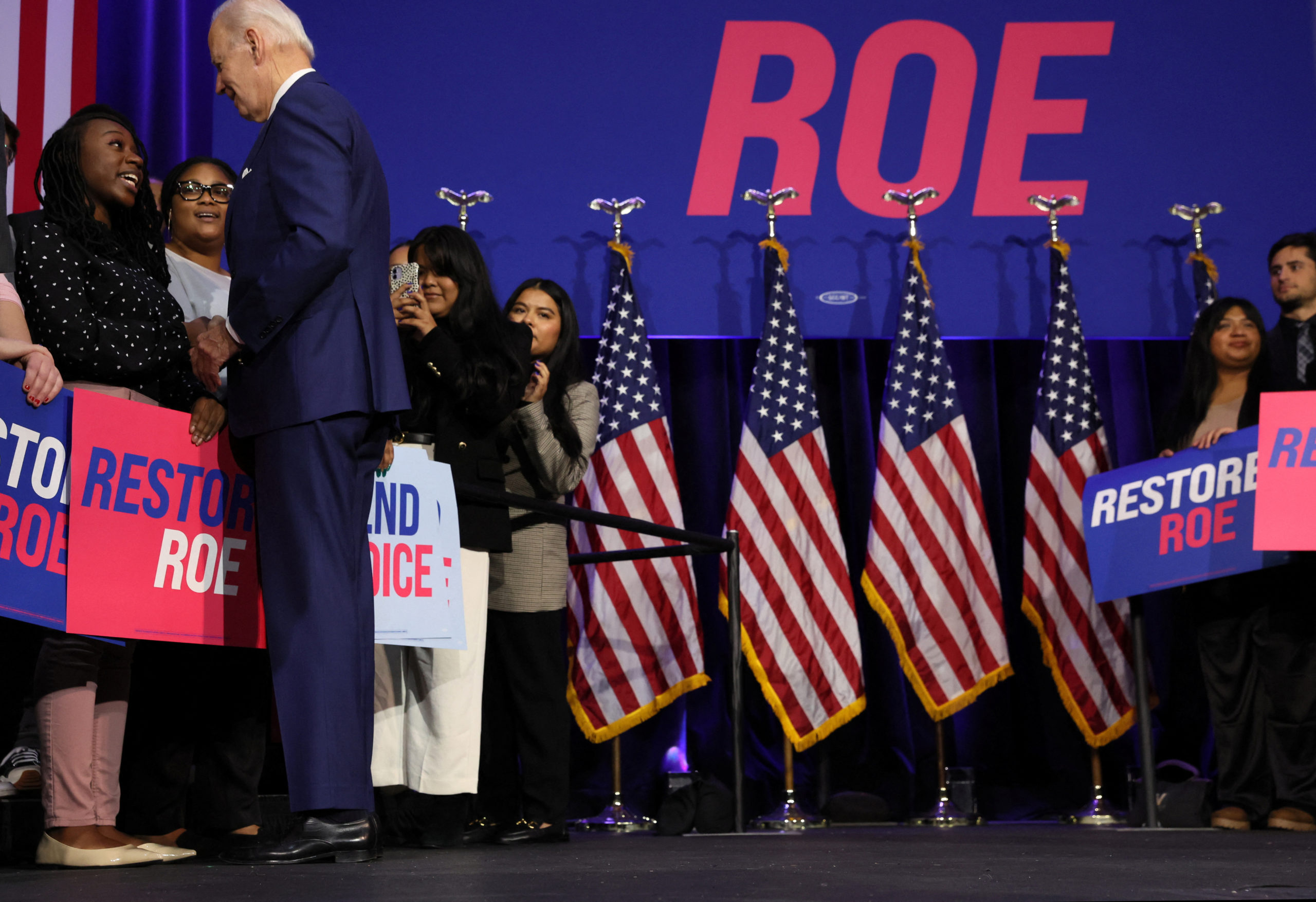 U.S. President Joe Biden greets people who stood on the stage behind him as he delivered remarks on abortion rights in a speech hosted by the Democratic National Committee (DNC) at the Howard Theatre in Washington, U.S., October 18, 2022. REUTERS/Leah Millis