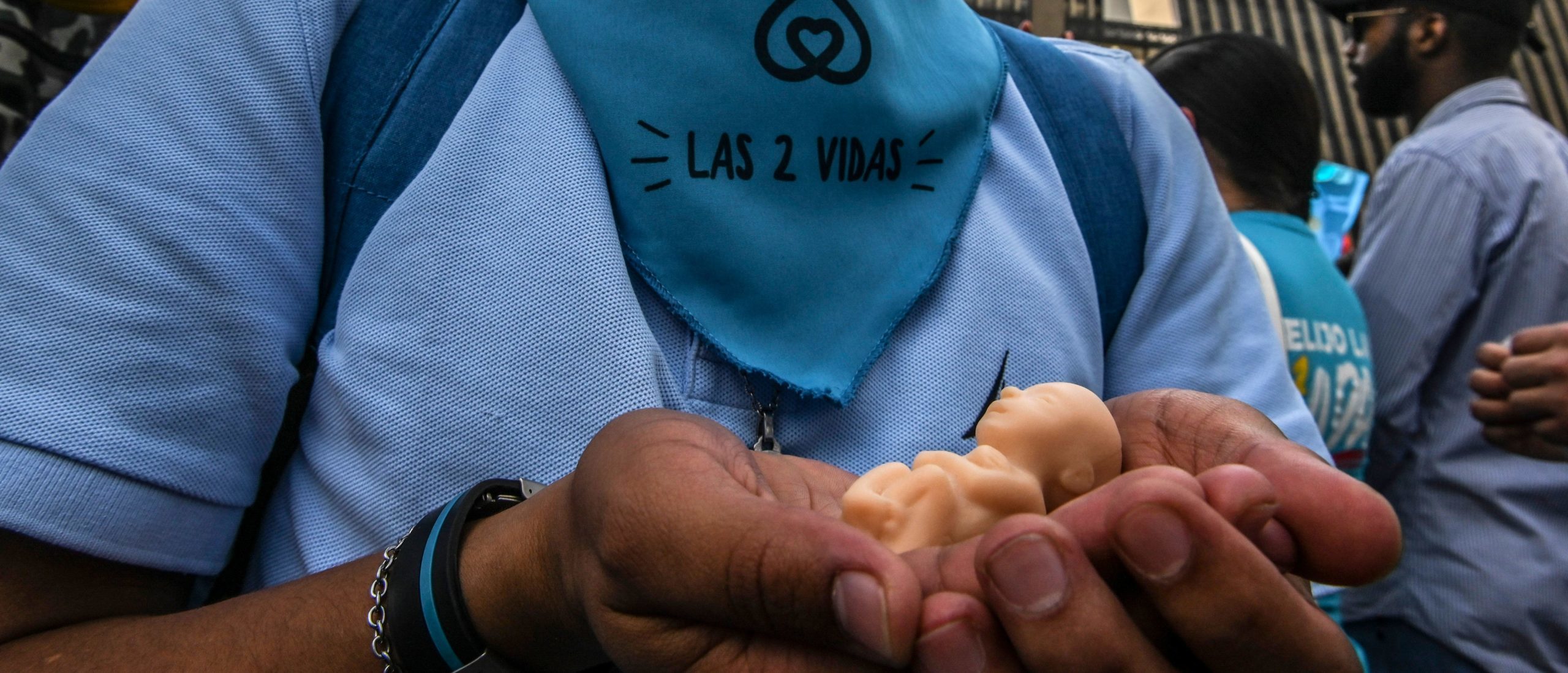 A man wearing a blue headscarf reading "The two lives", holds a replica of a fetus during a protest against the legalization of abortion in Medellin, Colombia, on February 19, 2020. (Photo by JOAQUIN SARMIENTO / AFP)