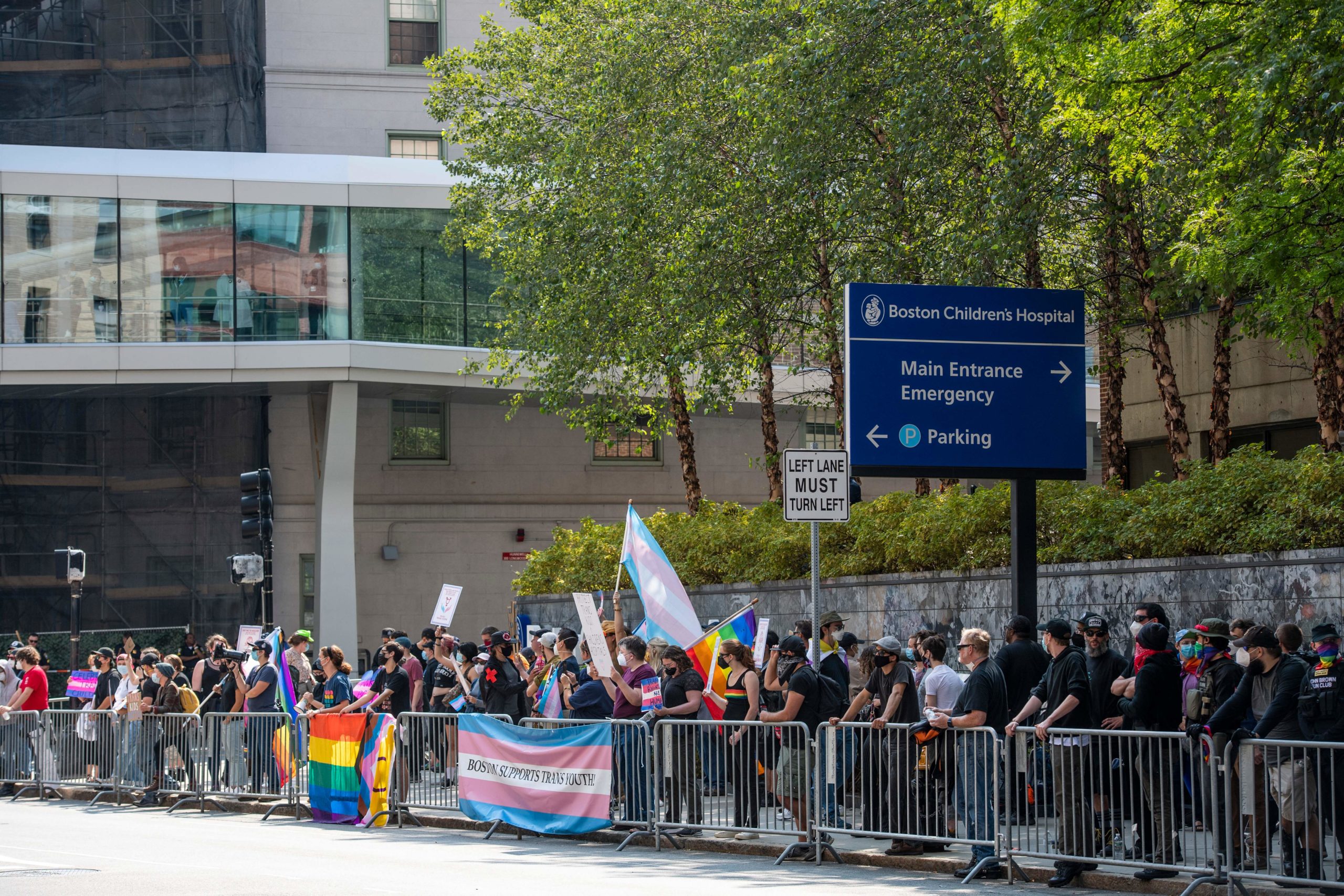 Medical workers watch as demonstrators in support of trans-children and gender affirmation treatments rally outside of Boston Childrens Hospital in Boston, Massachusetts, on September 18, 2022. (Photo by Joseph Prezioso / AFP) 