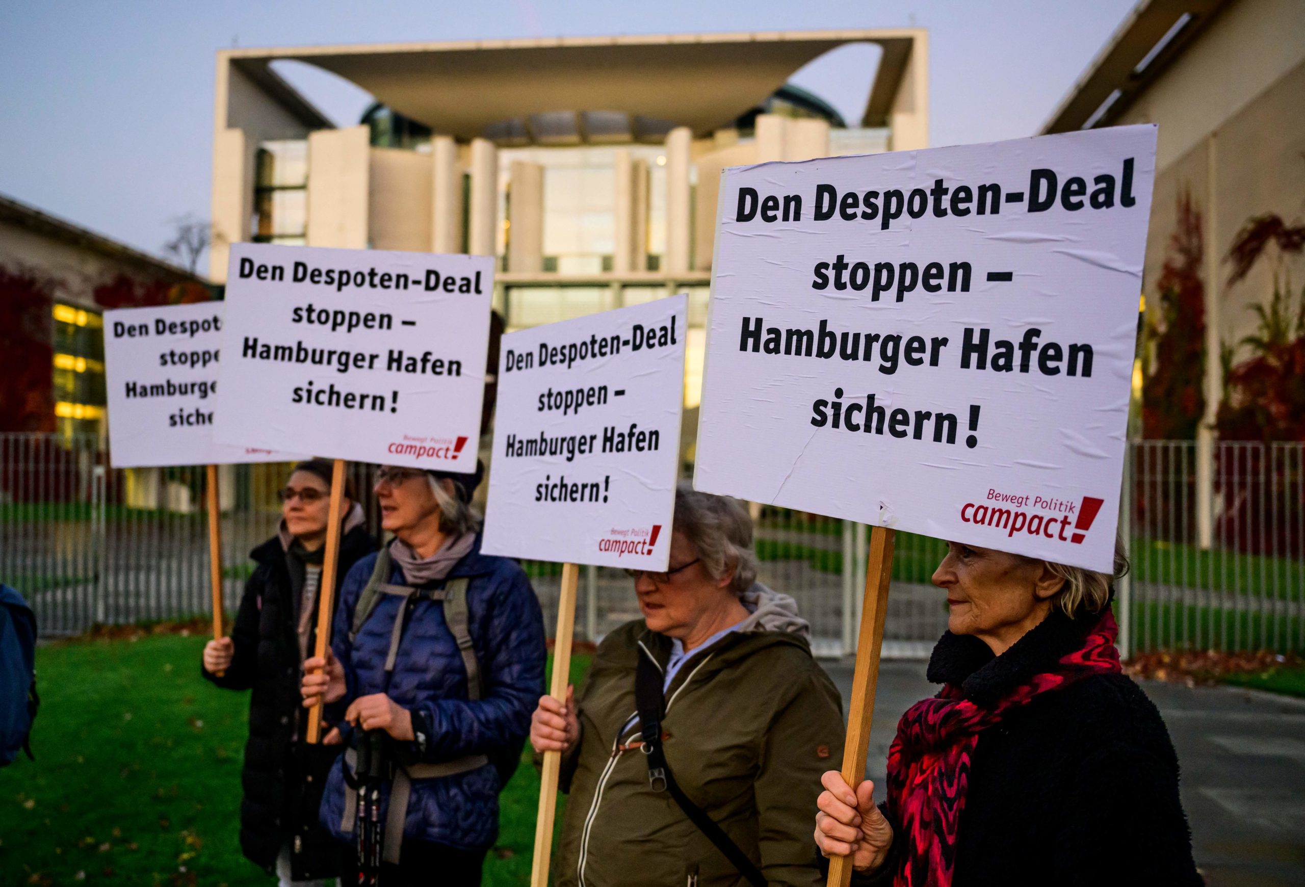 Activists display placards reading: "Stop the despot deal, secure Hamburg's port" during a protest in front of the chancellery in Berlin on October 26, 2022, referring to Chinese shipping firm Cosco's plan to acquire a major stake in a container terminal at the port. - The German government approved a controversial Chinese investment in a Hamburg port but limited the scale of the purchase, citing threats "to public order and safety."