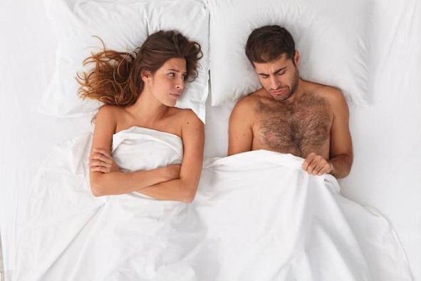A woman and a man, having impotence issues, in bed
