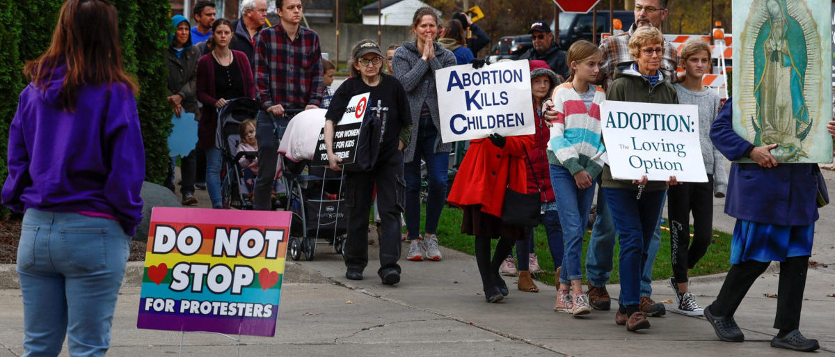 An abortion clinic escort watches Catholic groups pass Northland Family Planning during a prayer march to demonstrate against the ballot measure known as Proposal 3, which would codify the right to abortion, in Westland, Michigan, U.S., November 5, 2022. REUTERS/Evelyn Hockstein