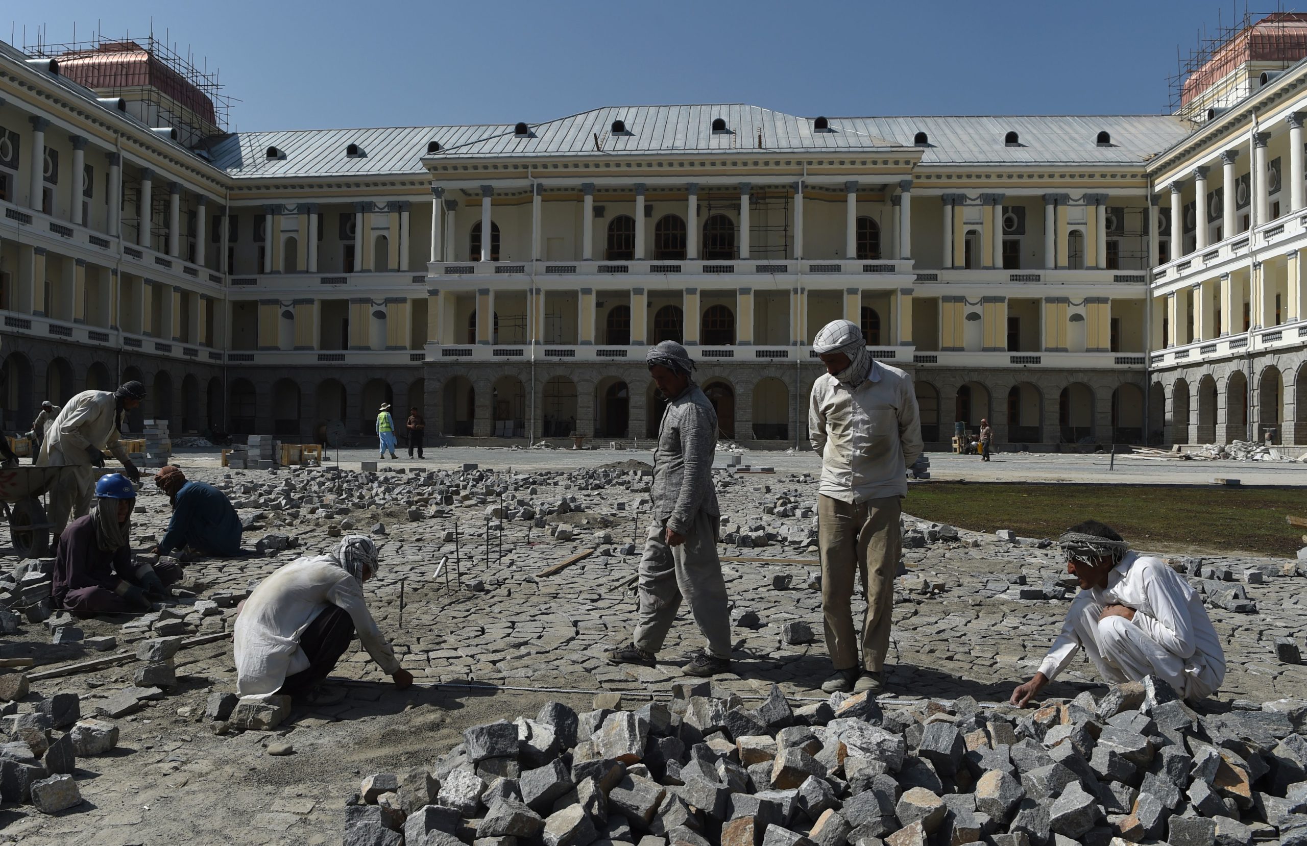 In this photo taken on August 8, 2019 Afghan labourers work on the exterior renovation of Darulaman Palace in Kabul. - Work to completely renovate the once-ruined Darulaman Palace must be completed by August 19, the date marking 100 years of Afghan independence from Britain, when President Ashraf Ghani will inaugurate the newly finished structure that has came to reflect the country's turmoils during decades of war.