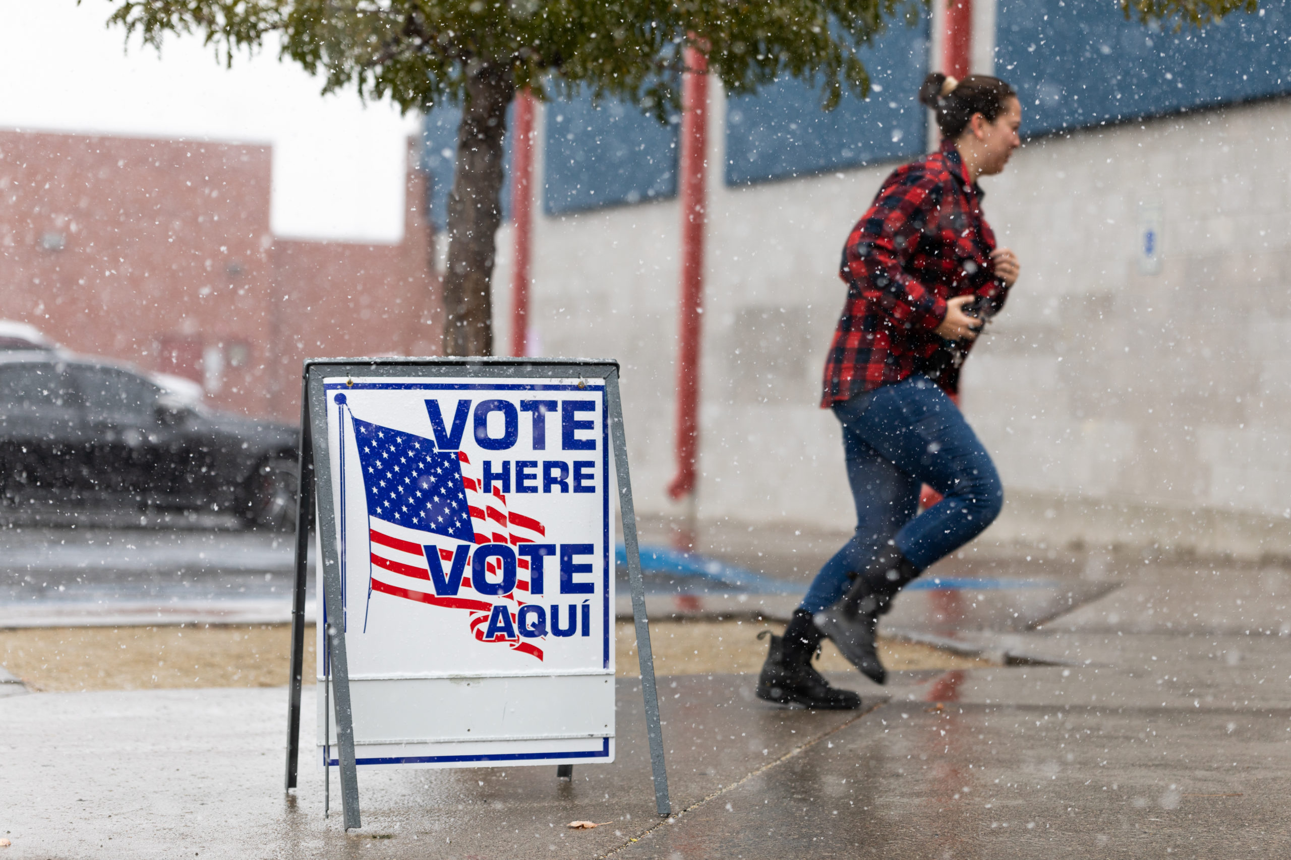 A Washoe County voter runs through the snow to cast their ballot inside Reno High School on November 8, 2022 in Reno, Nevada. After months of candidates campaigning, Americans are voting in the midterm elections to decide close races across the nation. (Photo by Trevor Bexon/Getty Images)