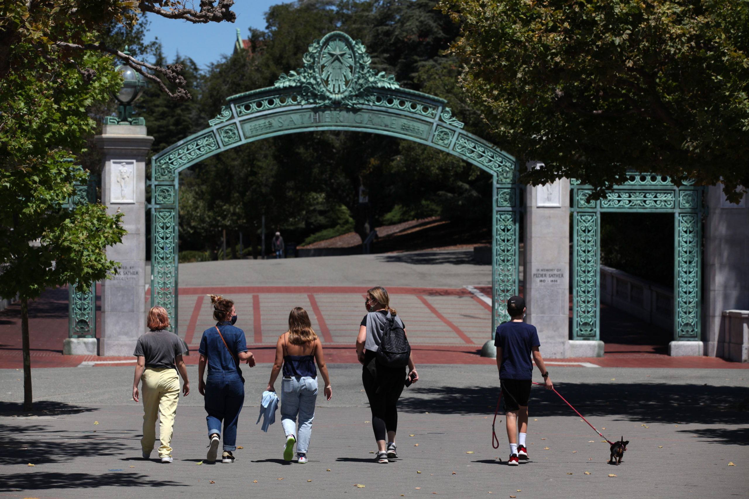 People walk towards Sather Gate on the U.C. Berkeley campus on July 22, 2020 in Berkeley, California. U.C. Berkeley announced plans on Tuesday to move to online education for the start of the school's fall semester due to the coronavirus COVID-19 pandemic. (Photo by Justin Sullivan/Getty Images)