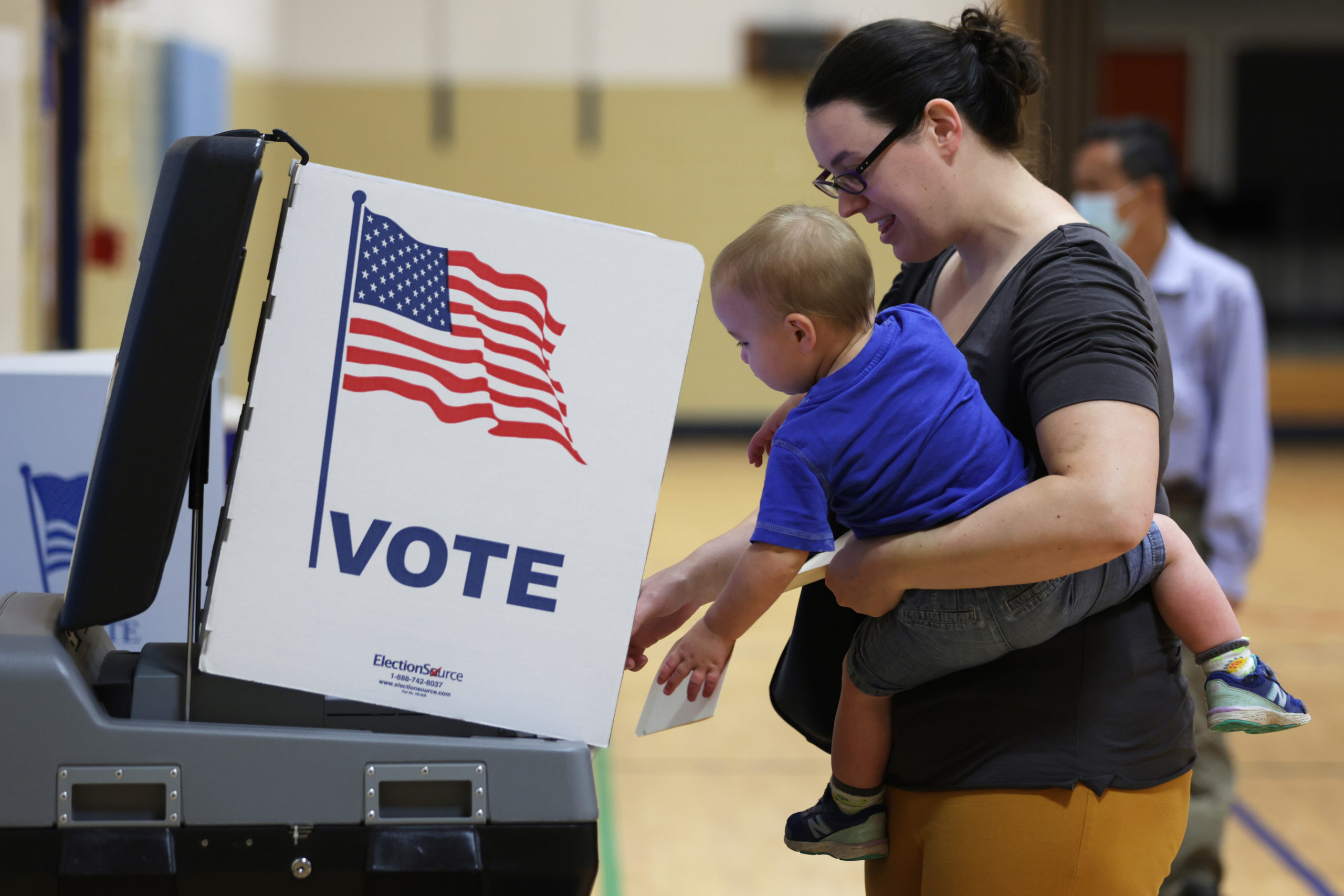 ALEXANDRIA, VIRGINIA - JUNE 21: A voter casts her ballot with her child at a polling station at Rose Hill Elementary School during the midterm primary election on June 21, 2022 in Alexandria, Virginia. (Photo by Alex Wong/Getty Images)