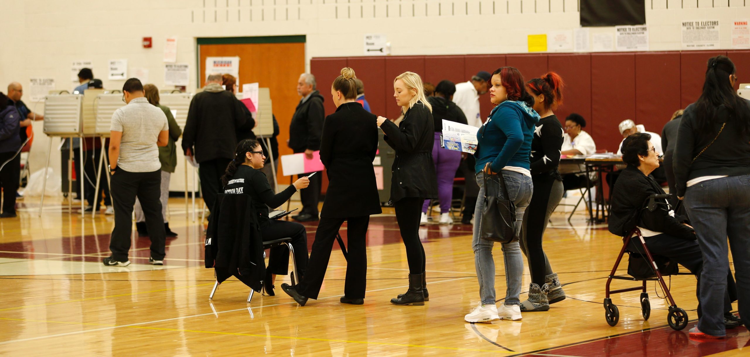 Detroit Election Worker Alondra Nava(C)directs voters at Western High School School in the US presidential election on November 8, 2016 in Detroit, Michigan. / AFP / JEFF KOWALSKY (Photo credit should read JEFF KOWALSKY/AFP via Getty Images)