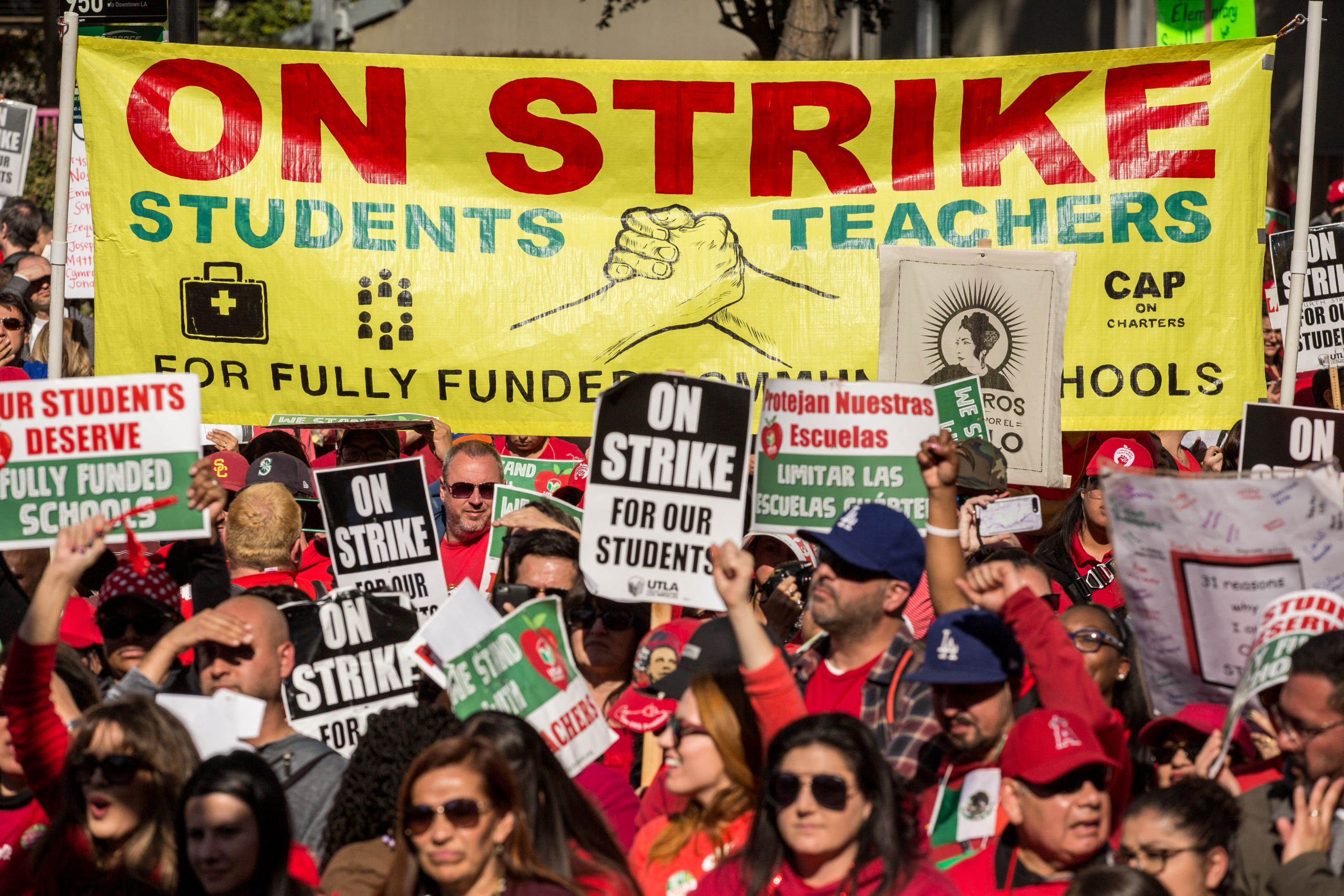 Educators, parents, students, and supporters of the Los Angeles teachers strike wave and cheer in Grand Park on January 22, 2019 in downtown Los Angeles, California.Thousands of striking teachers cheered for victory at the rally after it was announced that a tentative deal between the United Teachers of Los Angeles union and the Los Angeles Unified School District heavily favored educators' demands including a cap on rising class sizes, funding for school nurses, and a significant pay increase. (Photo by Scott Heins/Getty Images)
